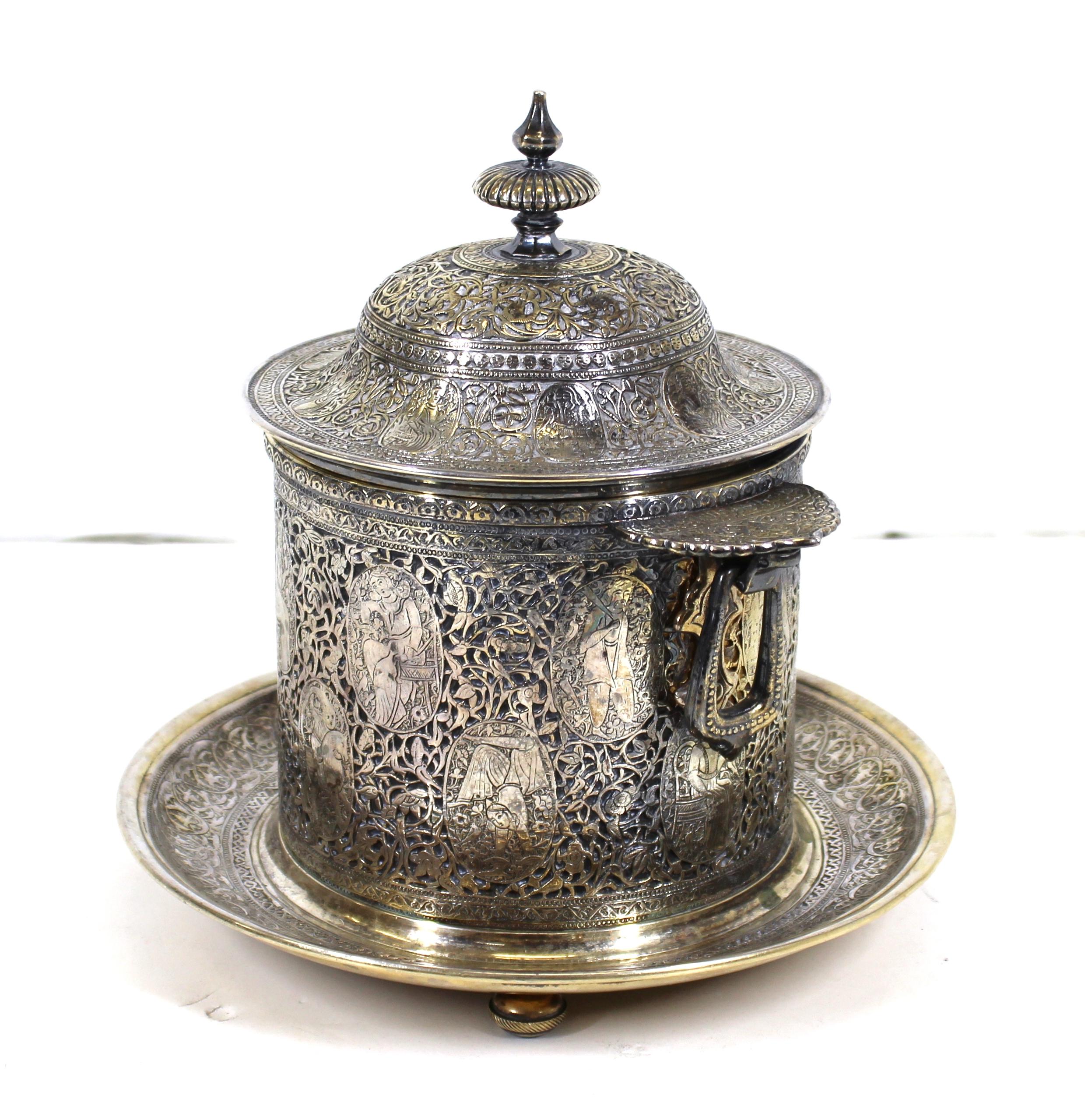 English Quajar style heavy silver plated biscuit box made by Mappin & Webb. The piece features a series of oblong portraits on the cylinder among elaborate foliage and arabesque motifs. Made in England in the late 19th century, likely during the