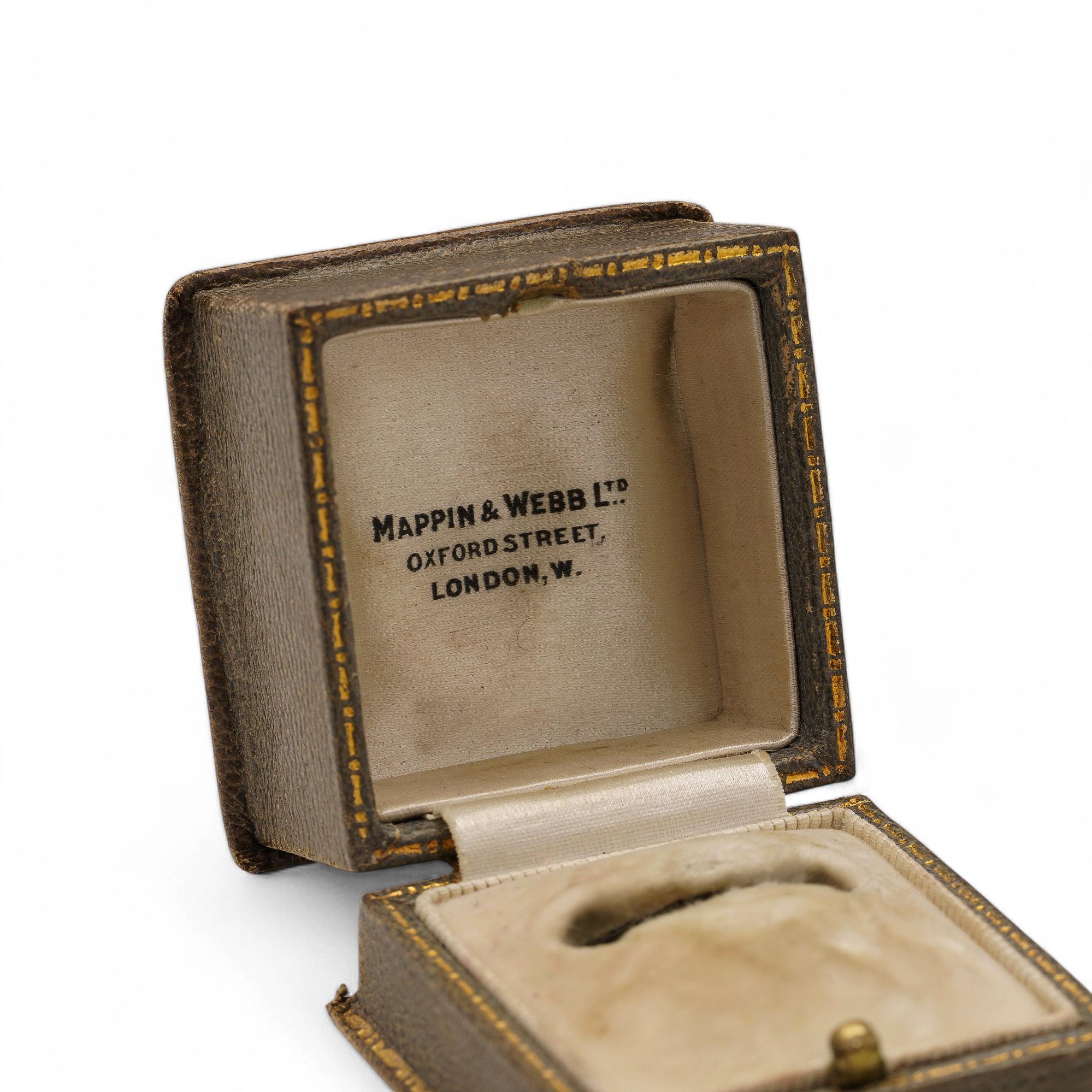 A small square ring box with a sophisticated exterior, likely crafted from leather. The interior features plush velvet and satin, designed to elegantly present a ring.

A refined ring box from Mappin & Webb, crafted with velvet and satin. Its