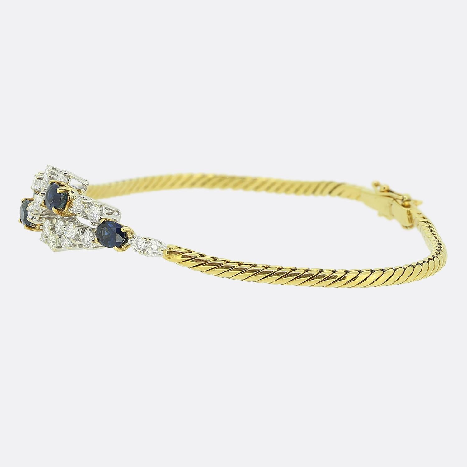 Nous avons ici un magnifique bracelet de la maison de joaillerie historique Mappin & Webb. Un chaleureux bracelet de style corde en or jaune 18ct suspend un fabuleux ensemble de pierres précieuses au centre. Quatre saphirs de couleur bleu marine