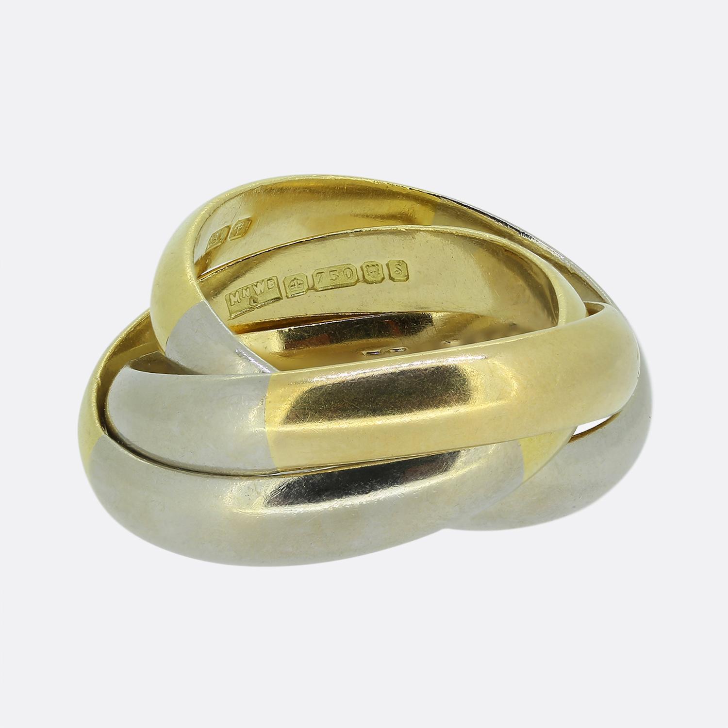 Aquí tenemos un anillo trinitario de banda bicolor fabricado por Mappin & Webb. El diseño presenta tres bandas entrelazadas, cada una de ellas fabricada con dos tipos de oro de 18 quilates, amarillo y blanco. Las bandas son lisas, creando un aspecto