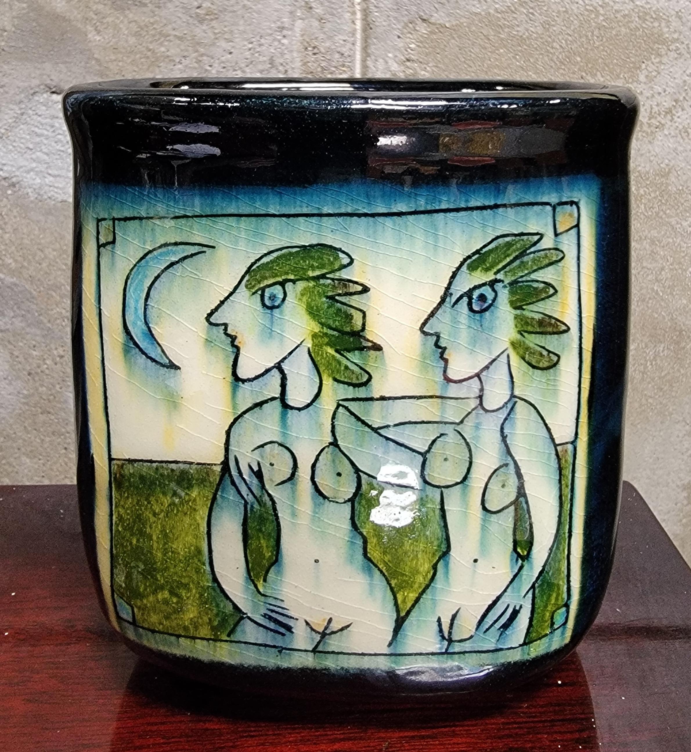 Un vase en grès, décoré à la main par Mara. Décor sur les deux côtés du vase représentant 2 nus. Les figures semblent être diurnes et nocturnes. Remarquez la lune sur un panneau et le soleil sur l'autre. L'artiste s'est peut-être inspiré de Pablo
