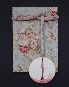 Gemischte Wandkomposition mit Stickereireifen und Katzenmotiv auf geblümtem Stoff