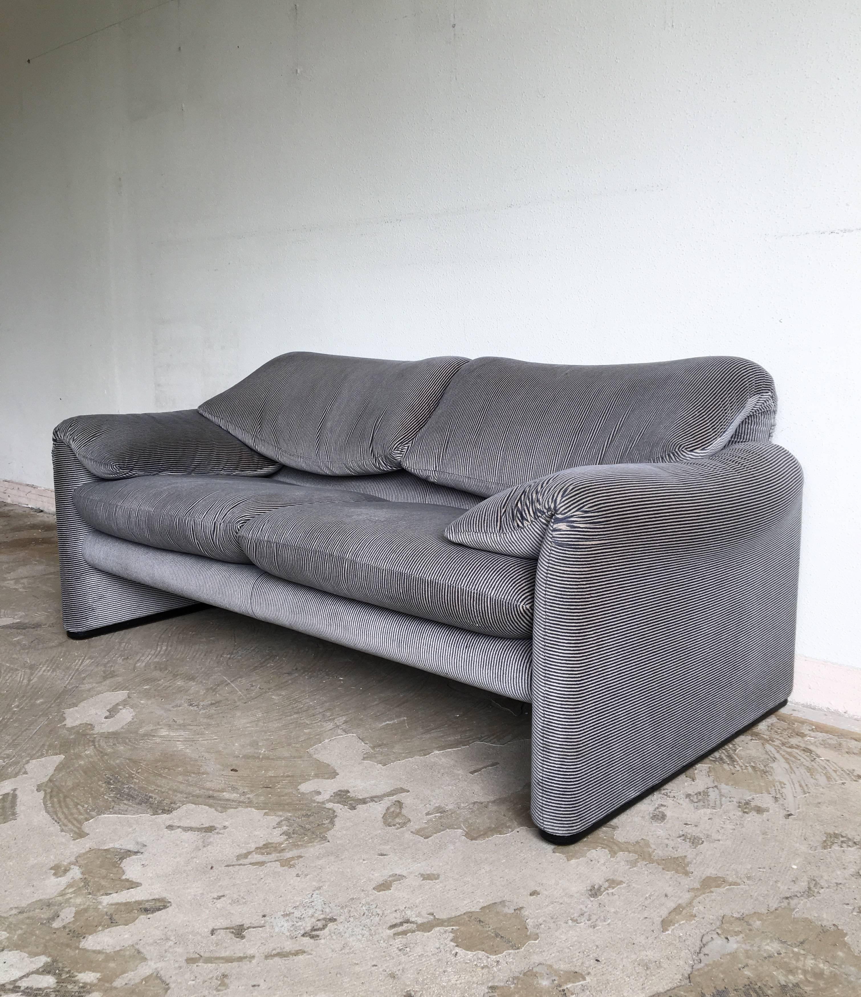 Two-seat sofa in soft, two-toned color fabric. Very nice piece which was designed by Vico Magistretti and manufactured by Cassina. The sofa remains in good overall condition but might show wear consistent with age and use, for instance color change