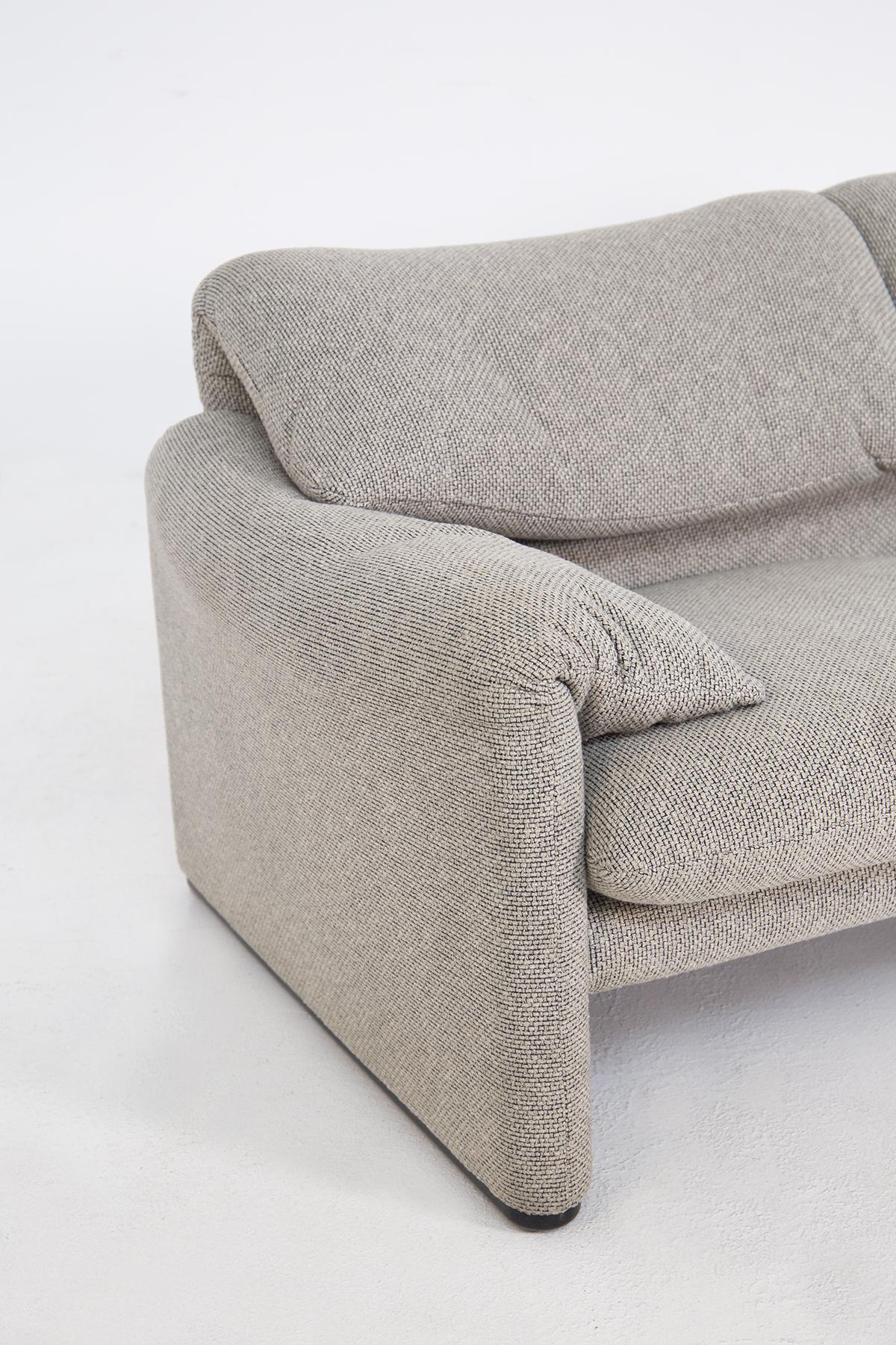 Sofa designed by Vico Magistretti for the Cassina factory in the 1970s. The two-seater sofa is upholstered entirely in grey woven fabric. With its warm and reassuring shapes, where the possibility of movement of the backrest, the soft appearance and