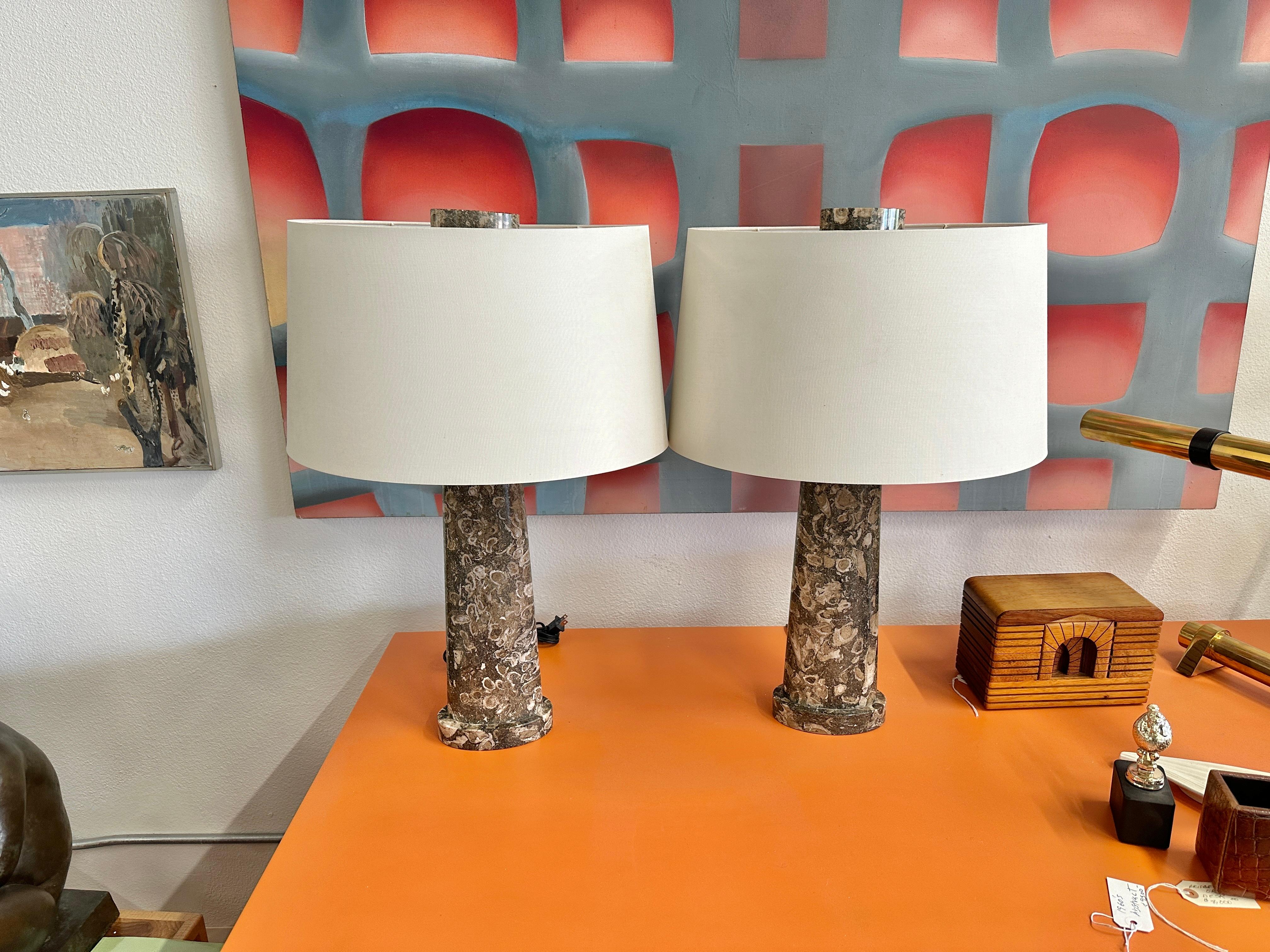 A lovely set of Baker lamps designed by Thomas Pheasant called the Adonis lamp. Crafted of beautifully grained marble, with lovely matching marble finials. These lamps have the original shades. They are in good working condition. I believe they are