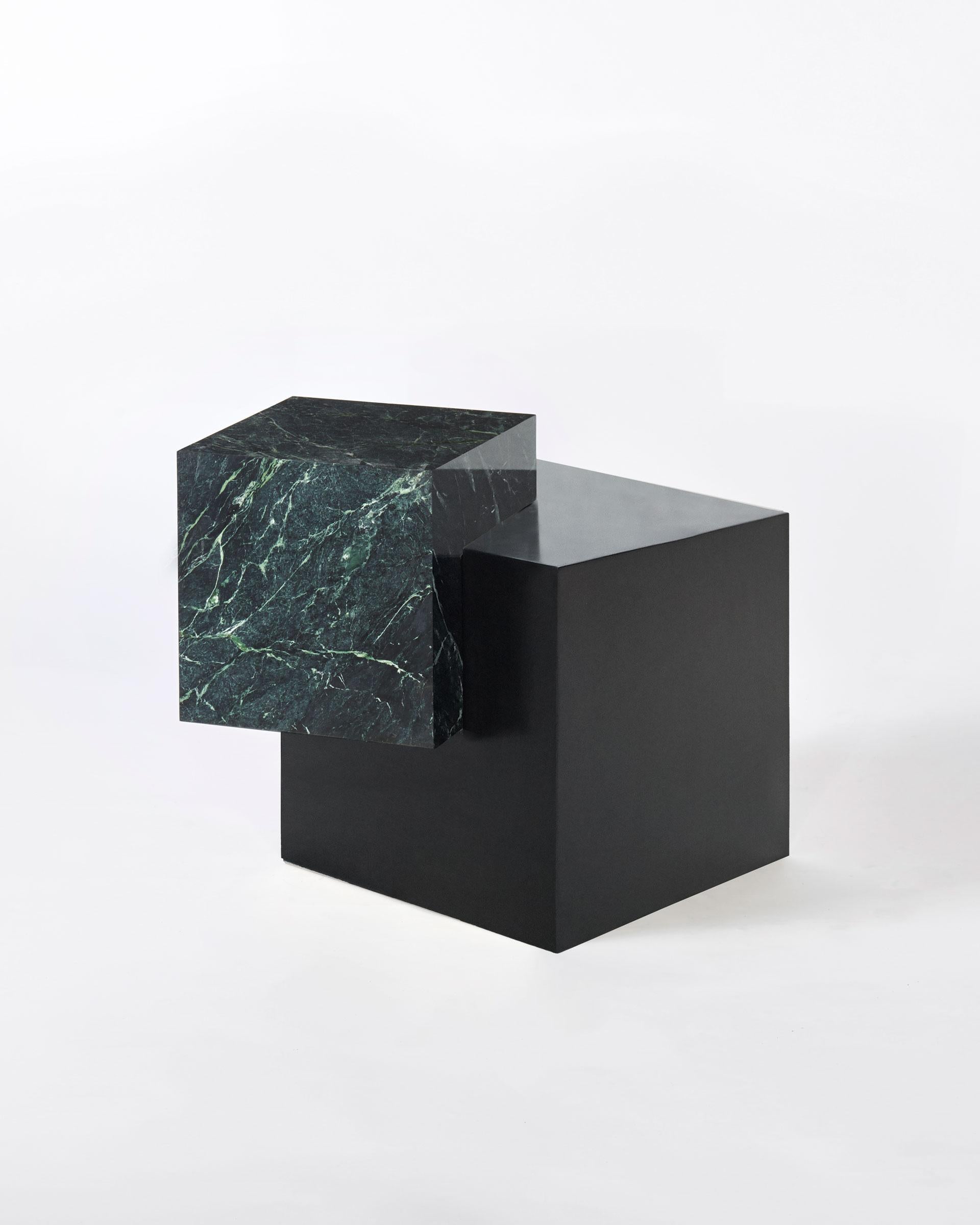 The coexist askew is an exploration of balance, material and harmony. The materials consist of a black steel cube base and a marble cube top.

The table features a marble cube balanced at an unexpected angle on the brass cube base. The two cubes