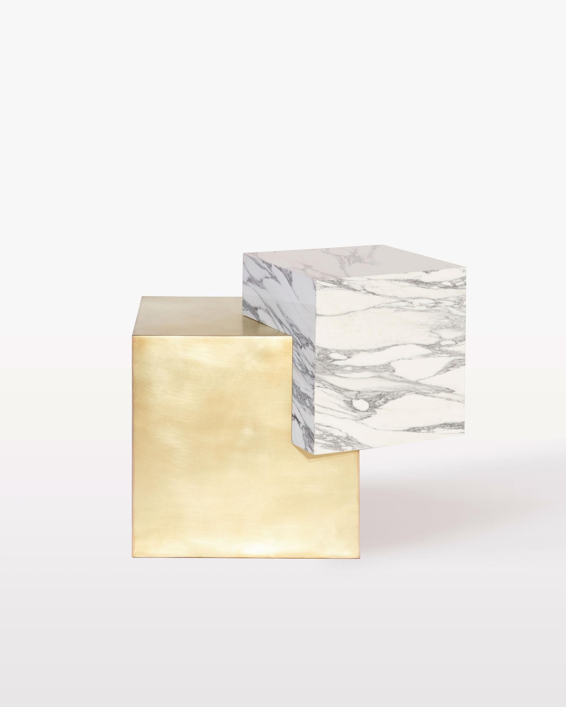 The coexist askew side table is an exploration of balance, material, and harmony. The materials consist of a brushed brass cube base and a marble cube top.

The table features a marble cube balanced at an unexpected angle on the brass cube base.