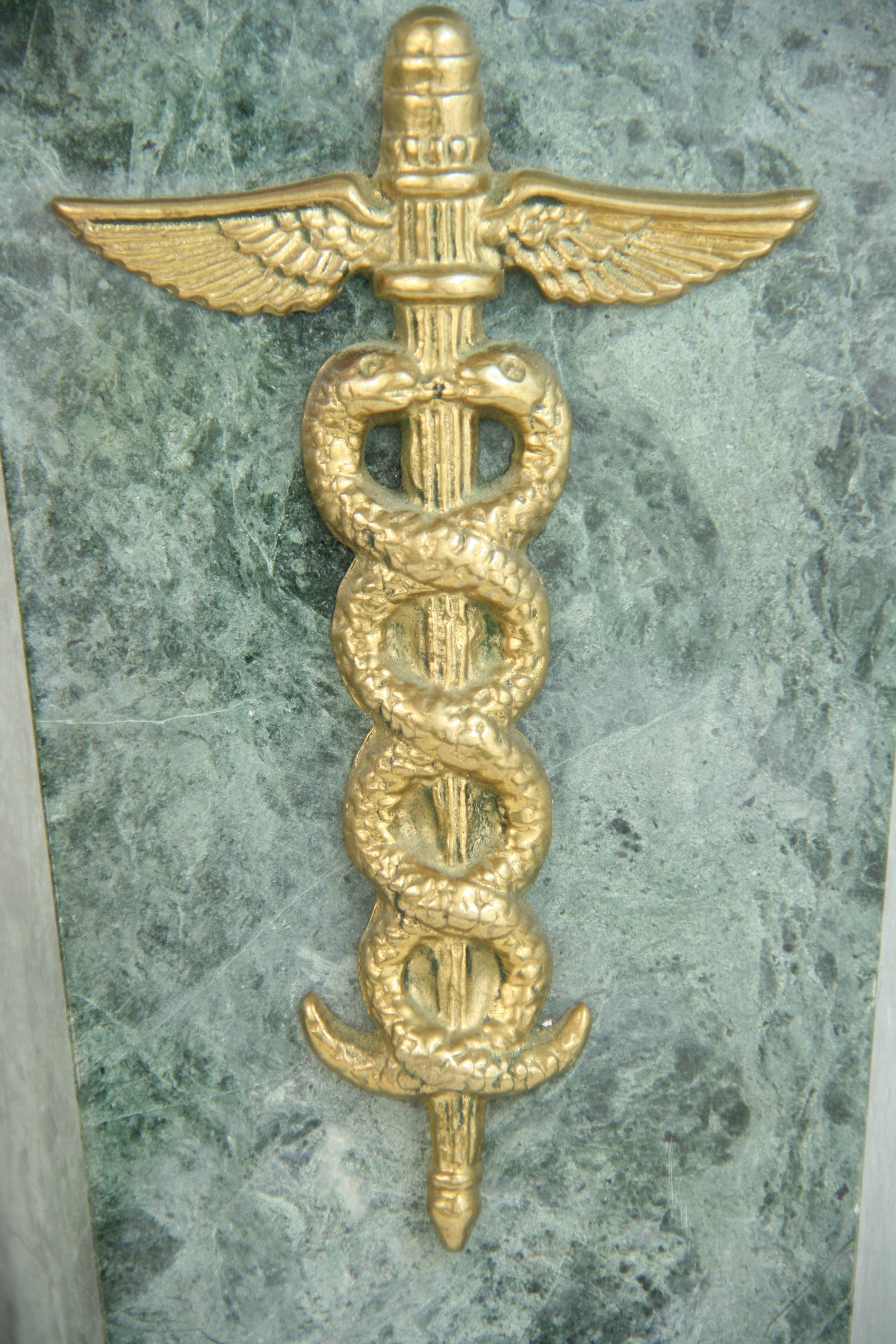 8-218 heavy green marble book ends with brass emblem of the medical profession.
