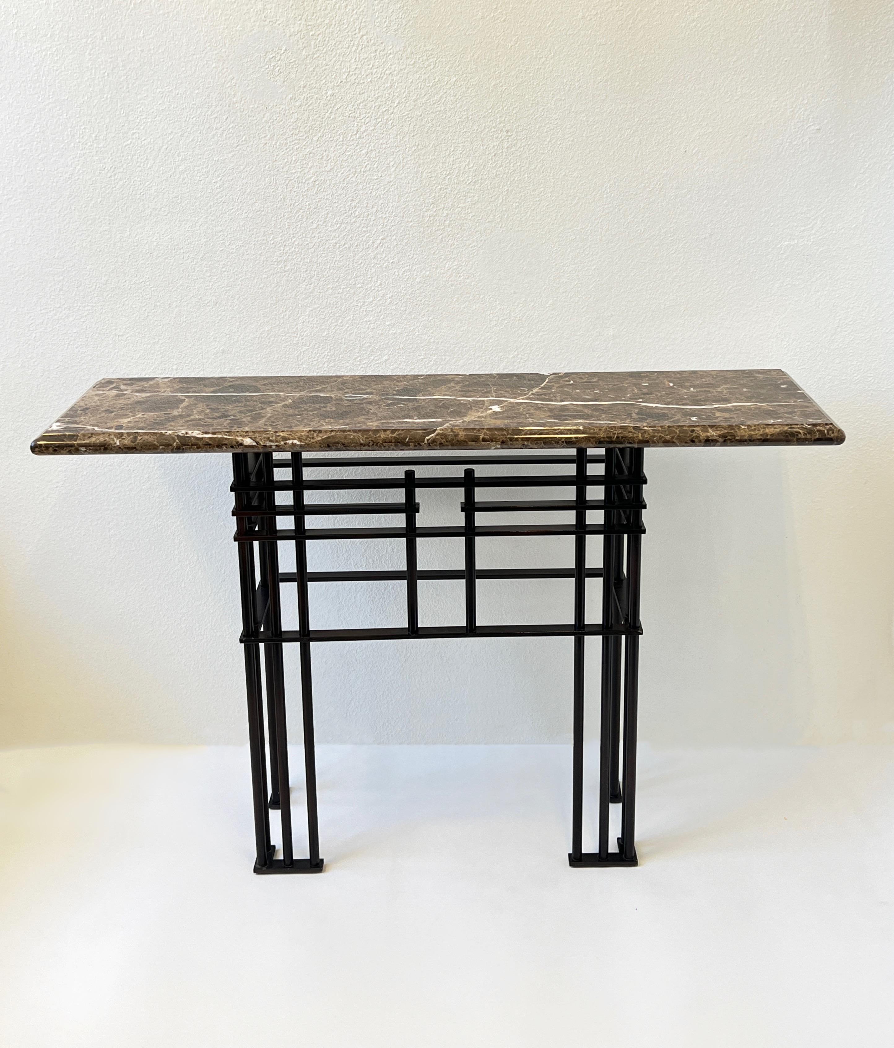 1980’s Console table designed by French architect Jean Michele Wilmotte for Mirak. 
Constructed of brown tones marble top with a steel powder coated bronze finish base. 
Measurements: 55” wide, 17” deep, 36.25” high.