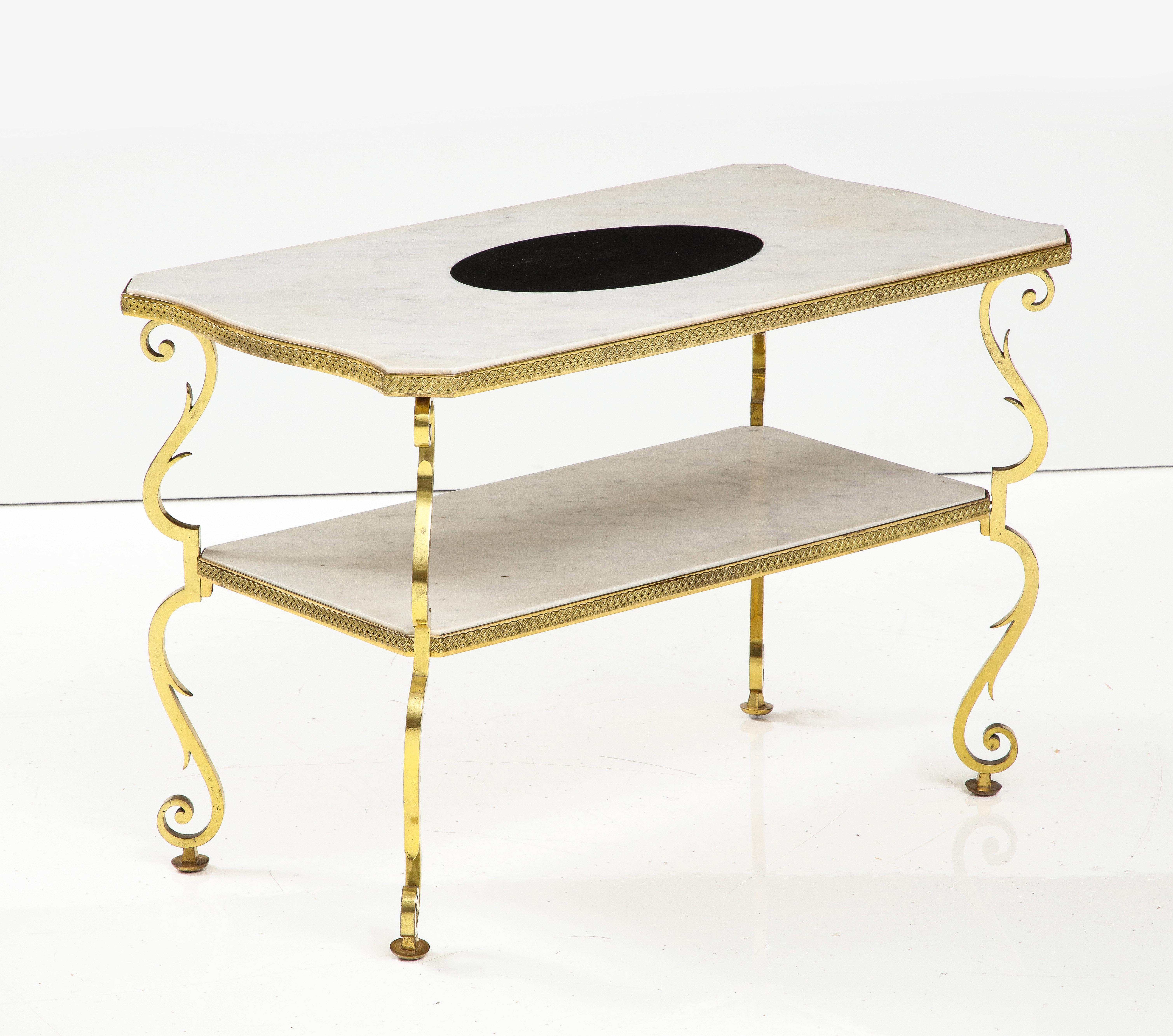 Table d'appoint en marbre et bronze doré de Gilbert Poillerat, France, c. 1950. 

Cette rare et splendide table d'appoint se compose d'un cadre en bronze doré, de pieds végétaux à volutes et de deux étages de plateaux en marbre. Des garnitures