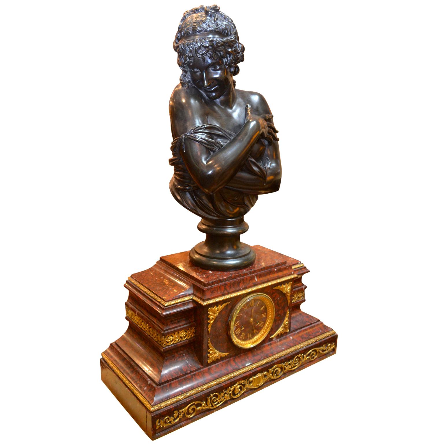 A finely cast gilt bronze clock base mounted with of a classical patinated bronze bust of a maiden after a model by James Pradier. The maiden has her curly haired head turned demurely to one side resting on her bare shoulders, and hands clasped