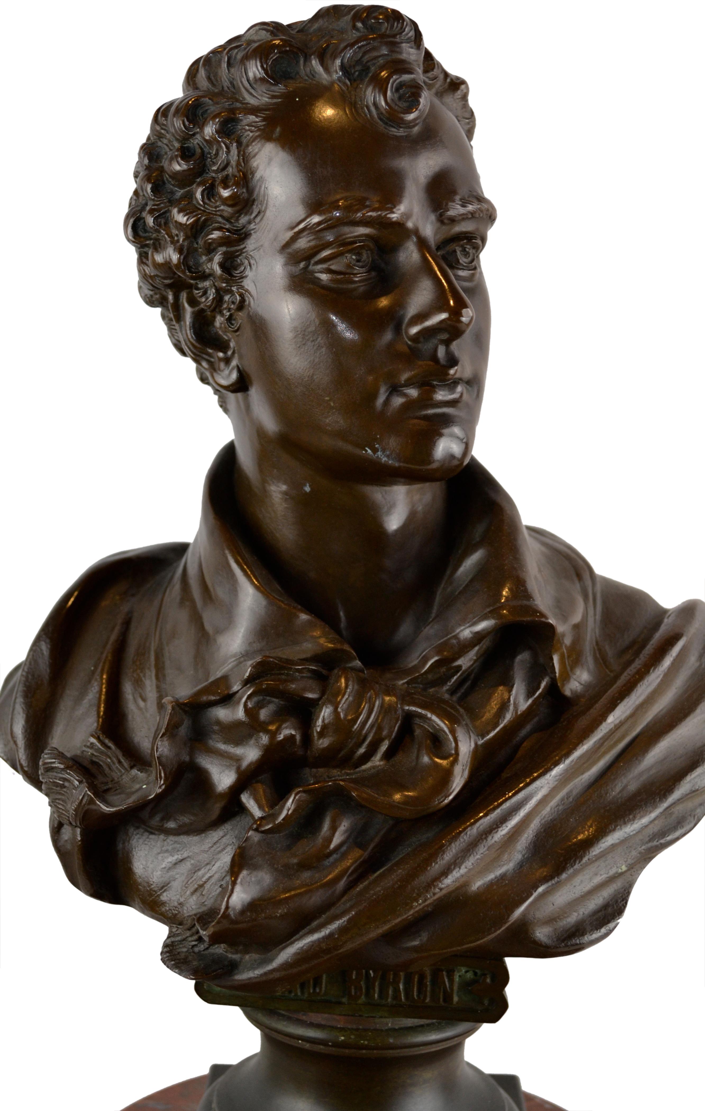 A finely cast bronze bust of Lord Byron signed Hans Fromm on a marble clock base. The bronze itself is set on top of a round fluted griotte marble column base that holds the movement and the dial; the case decorated gilt bronze ormolu banding, trim