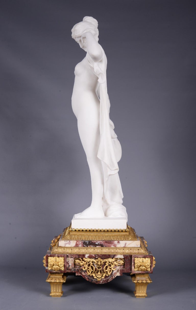 French Marble and gilt bronze clock surmounted by a statuary white marble sculpture For Sale