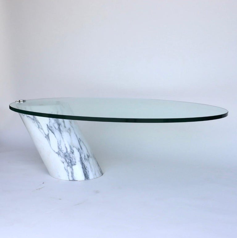 This is an incredible gravity-defying coffee table designed by Team Form for Ronald Schmitt in the 1970s. The base of this table is made from solid Carrera marble.
The thick oval glass top lays loose on the marble base only held in to place by a