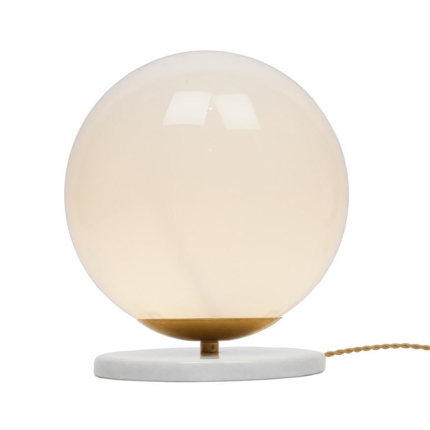 A simple modern table lamp to accent your living room, bedroom or work space. This contemporary globe lamp also works well in a commercial setting restaurant, retail, or office space.
Designed by Michele Varian
Glass, marble and brass
Overall
