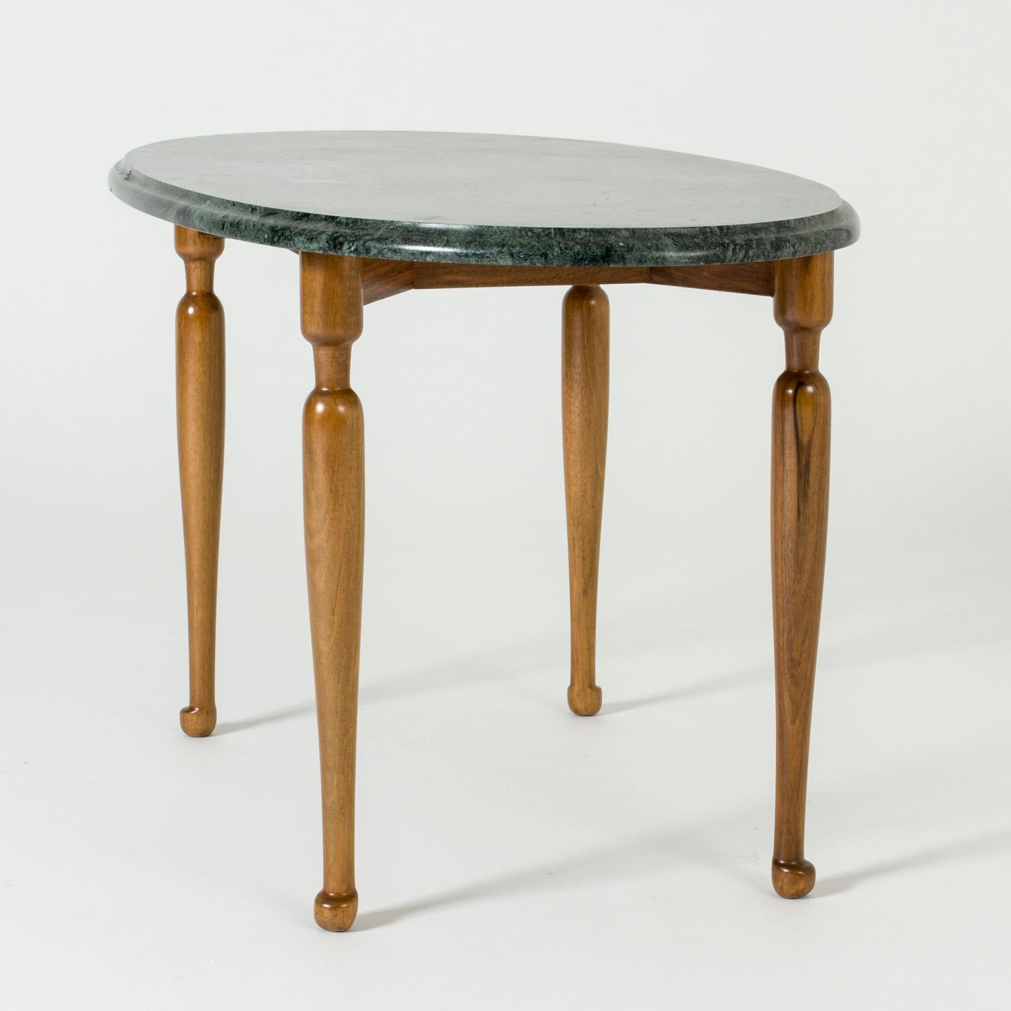 Schöner Beistelltisch von Josef Frank, mit einer ovalen Tischplatte aus grünem Marmor auf einem schlanken Mahagonisockel. Tiefgrüner Marmor, schöne skulptierte Beine und Füße.