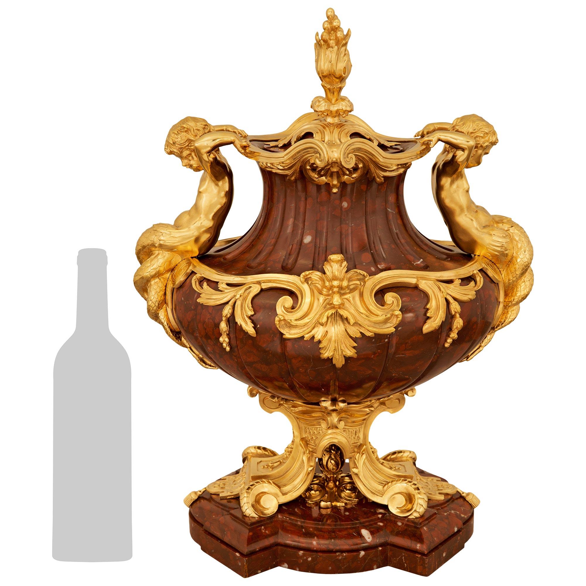 A sensational and most impressive French 19th century Louis XV st. Belle Epoque Period Rouge Griotte marble and Ormolu centerpiece/urn, attributed to Barbedienne. This stunning lidded urn, which is most likely by Barbedienne, is raised by a
