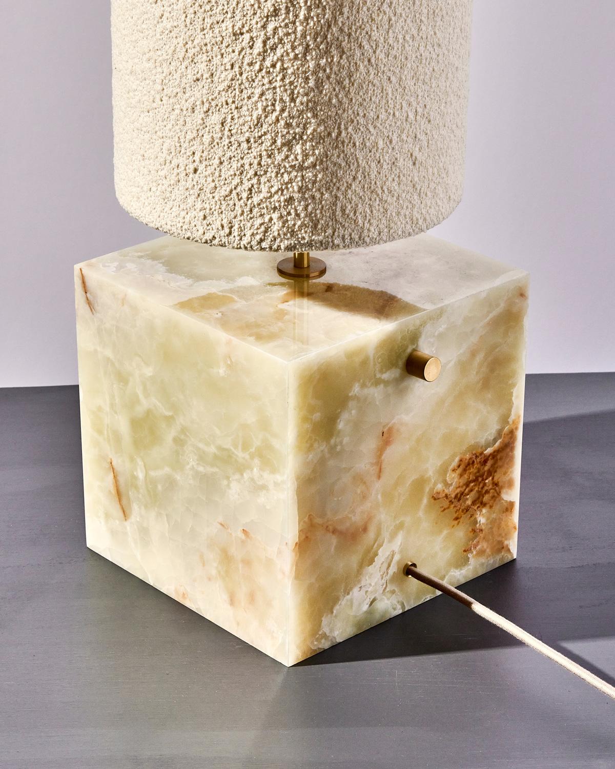 The coexist table lamp in Green Onyx and Bouclé Shade is a play on texture and color.

The lamp serves as a sculptural centerpiece for any room, emitting a soft warm light to draw the viewer into the materials. The bold geometry of the cube base
