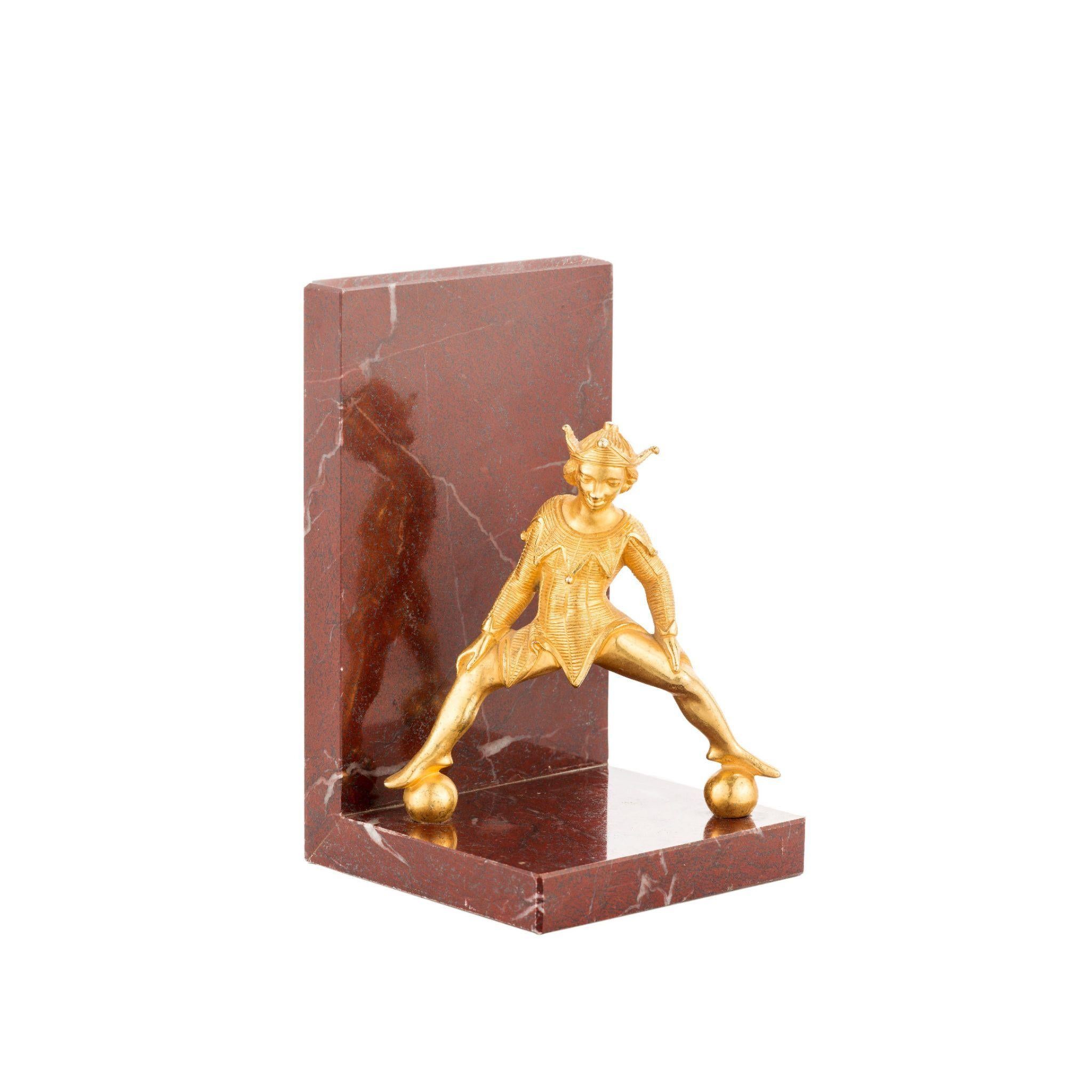 Add a touch of playfulness to your living space with our striking marble bookend featuring a brass jester. Not only is it a unique and eye-catching piece, but it's also practical for holding your books in place. Shop now and give your decor a touch