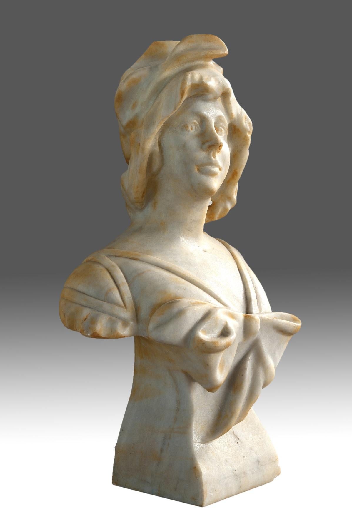 Female bust marble, 20th century.
Bust with base made of carved marble that shows a young lady with a treatment that recalls in some details modernist works from the beginning of the century, keeping in part a certain older tradition (material,