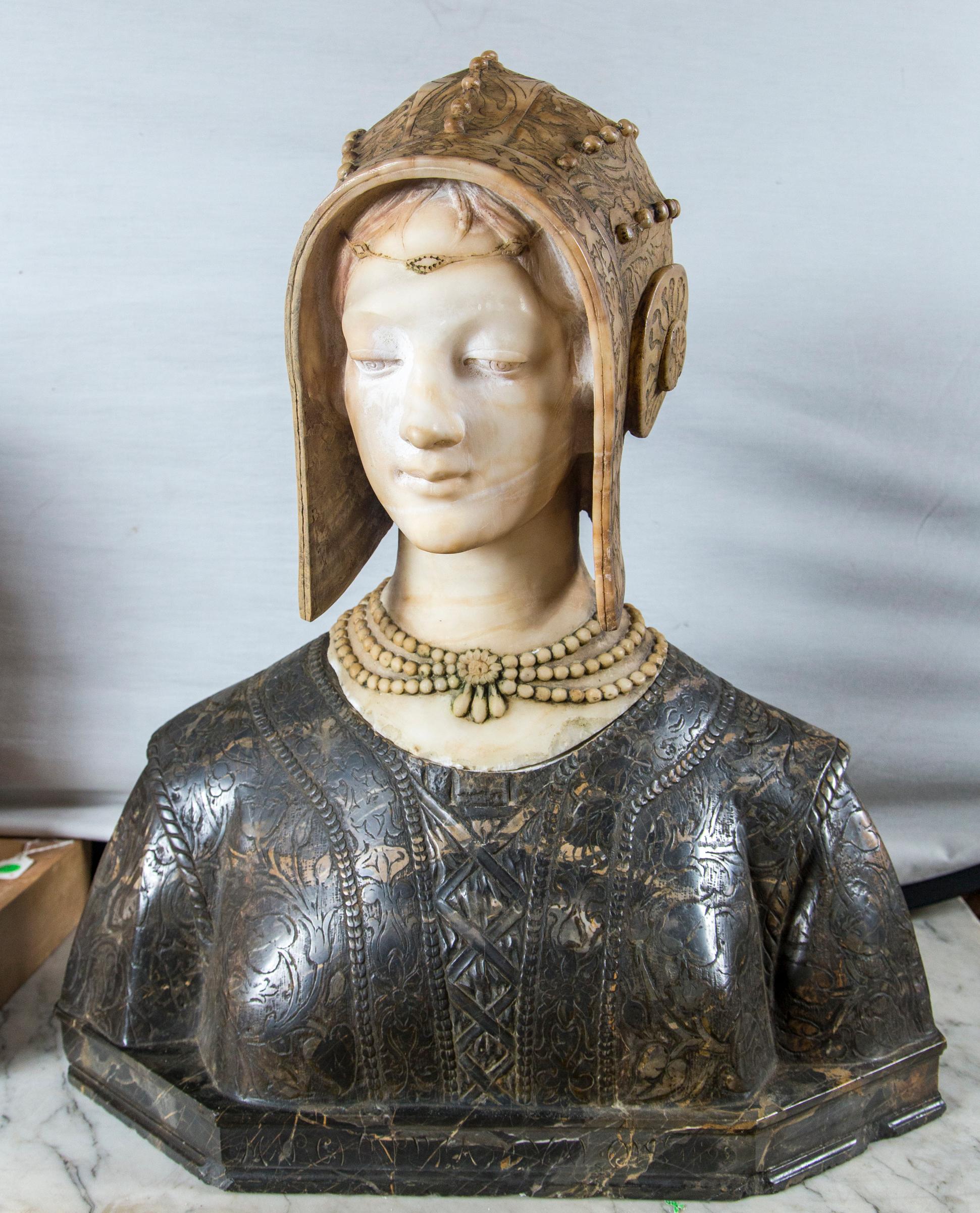 Her head carved separately and attached to the darker marble of her shoulders. There is a  metal  post   that hold  the  head to the  shoulders.  She wear a cloche hat, with incised decoration and appliques. Around her neck is a triple strand