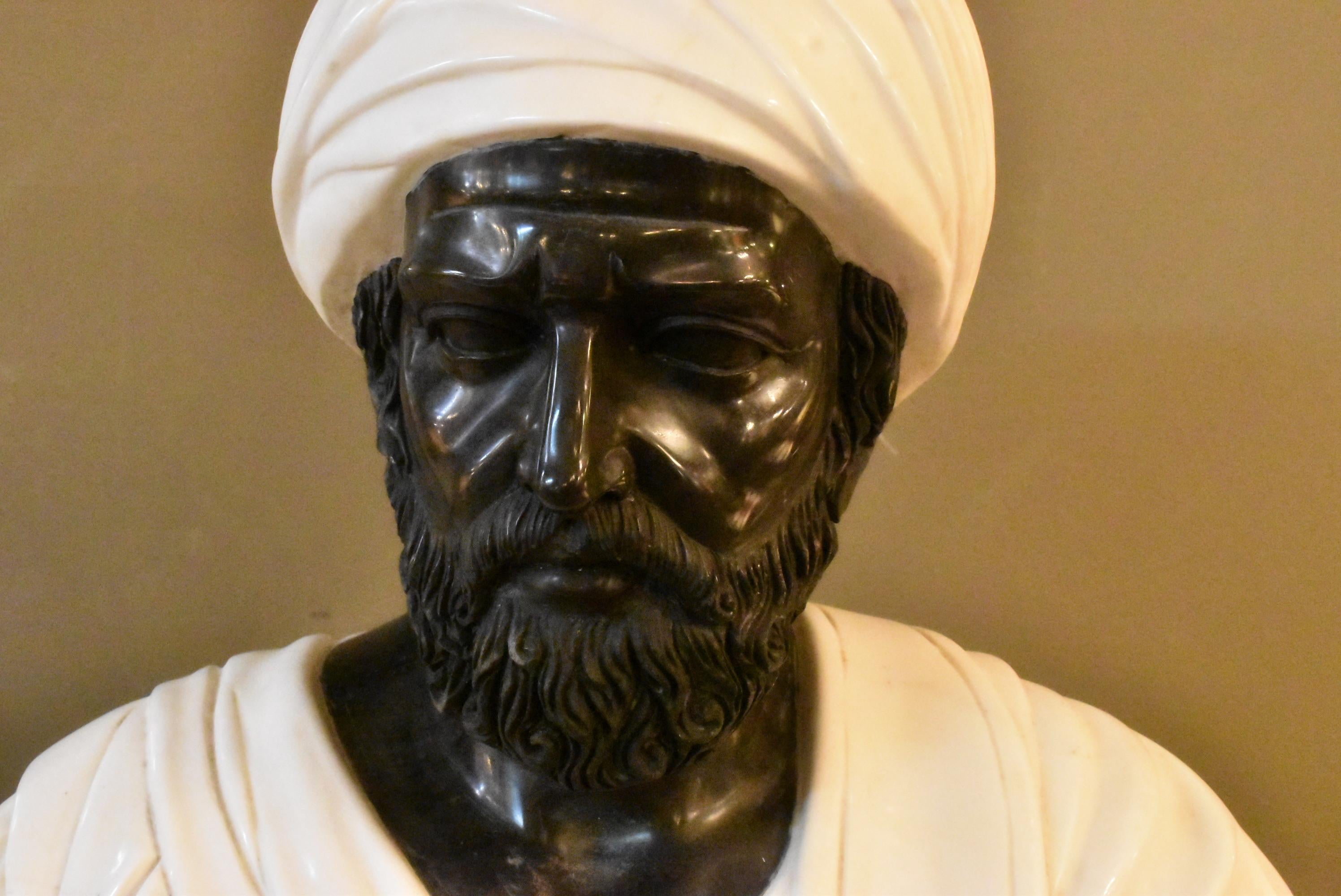 Marble bust of a Middle Eastern gentleman with white marble turban sitting on a dark green pedestal with white veining. Some small chips to the backside. Glue repair on collar of pedestal and comes apart into 5 pieces. Dimensions: 10