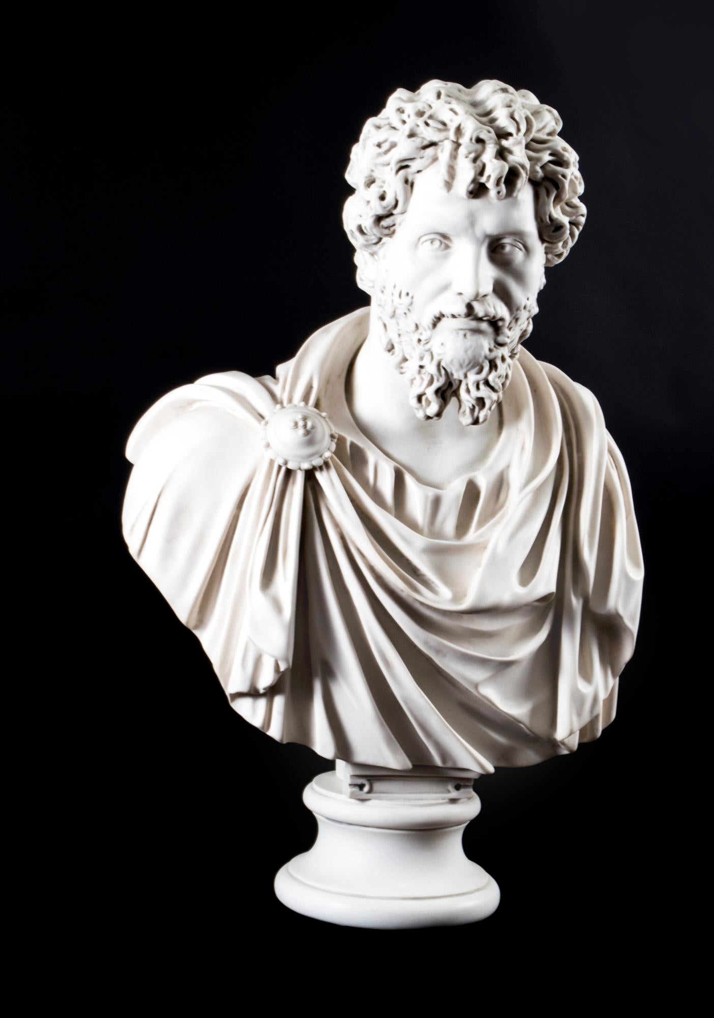 A beautifully sculpted marble bust of the famous Roman Emperor Lusias Versus dating from the last quarter of the 20th century. 

He is wearing a flowing toga with a fibulae or broach holding it in place, on a matching elegant pedestal in the form