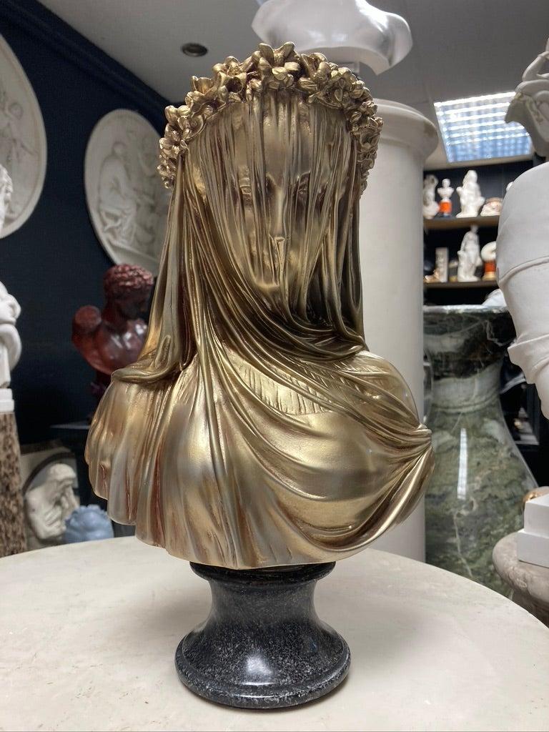 A stunning marble bust sculpture of veiled lady in antique gold, 20th century.

The Veiled Lady, a marble bust, after the antique sculpture, by Monti, 1875.

Finished in antique gold, and set upon a black and white granite socle.

This world
