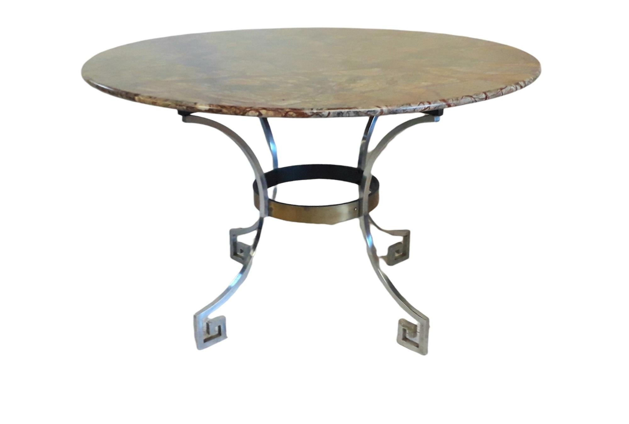 Marble Center Circular Dining Table.

1970s Chrome and Marble circular table with Greek key swept in leg design set with a joining brass band support.

Marble type is Rainforest Brown:
Rainforest Brown Marble is an extraordinary stone comprising