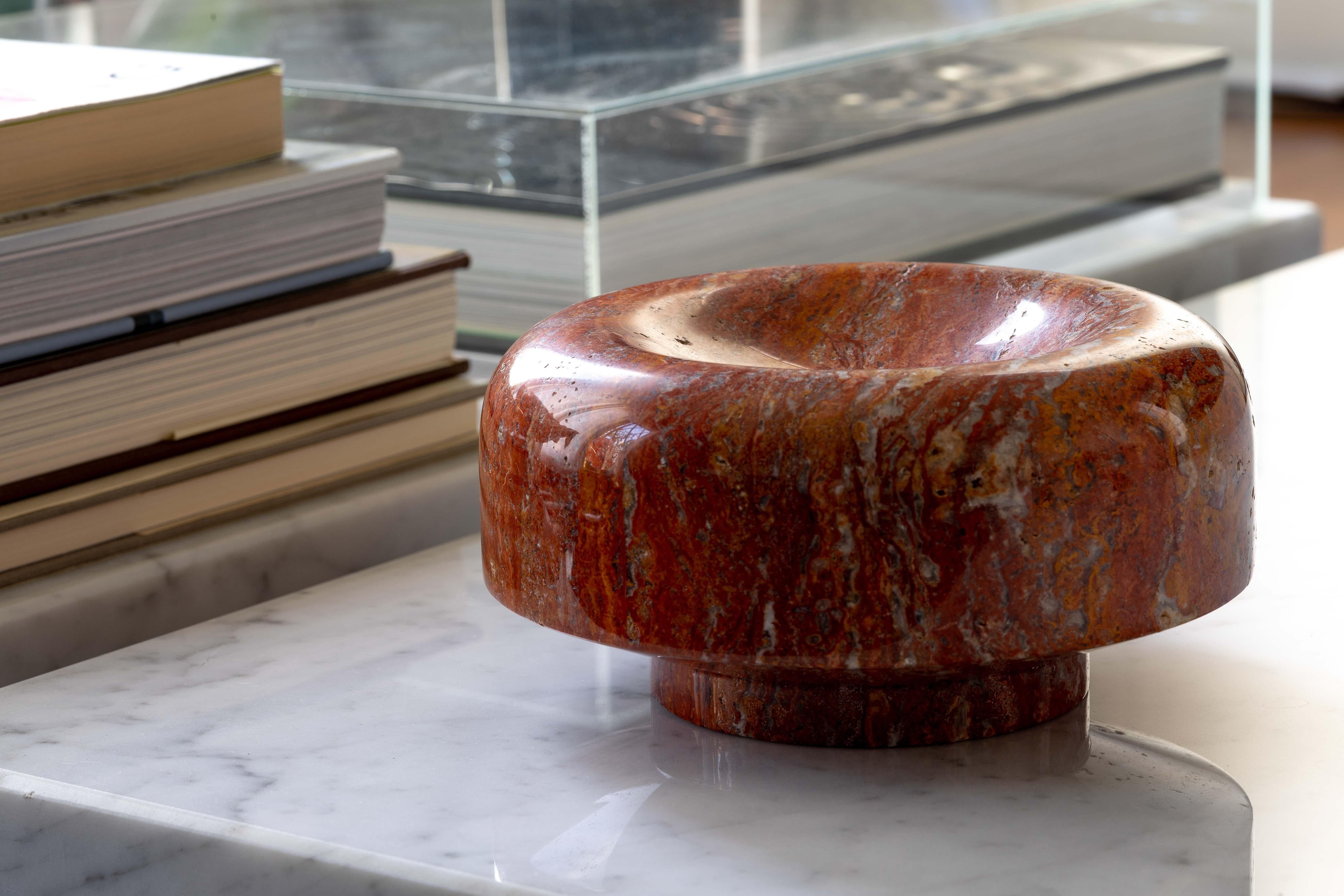 A striking marble centerpiece designed by Roberto Arioli for Gabbianelli in 1969. Expertly carved from a single block of reddish-orange marble, the centerpiece has a shallow concave recess on the top, with sides that angle down and under to create a