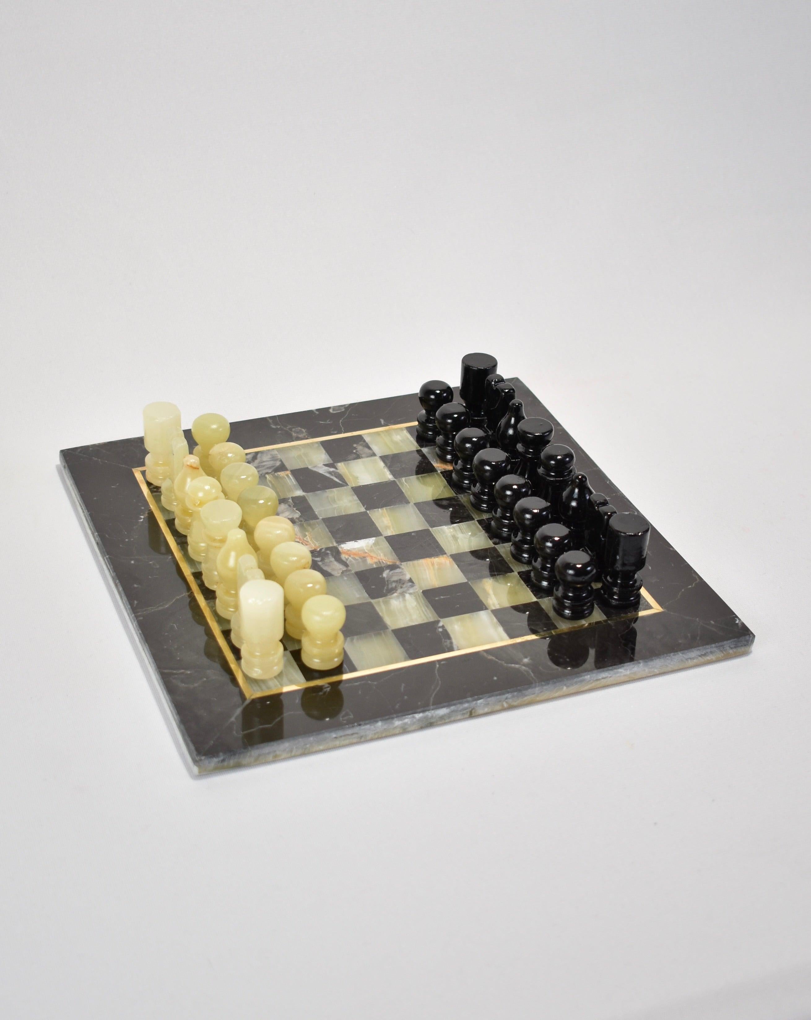 Marble and onyx chess board with brass inlay and hand carved pieces in black and pale green. Includes all 32 pieces.