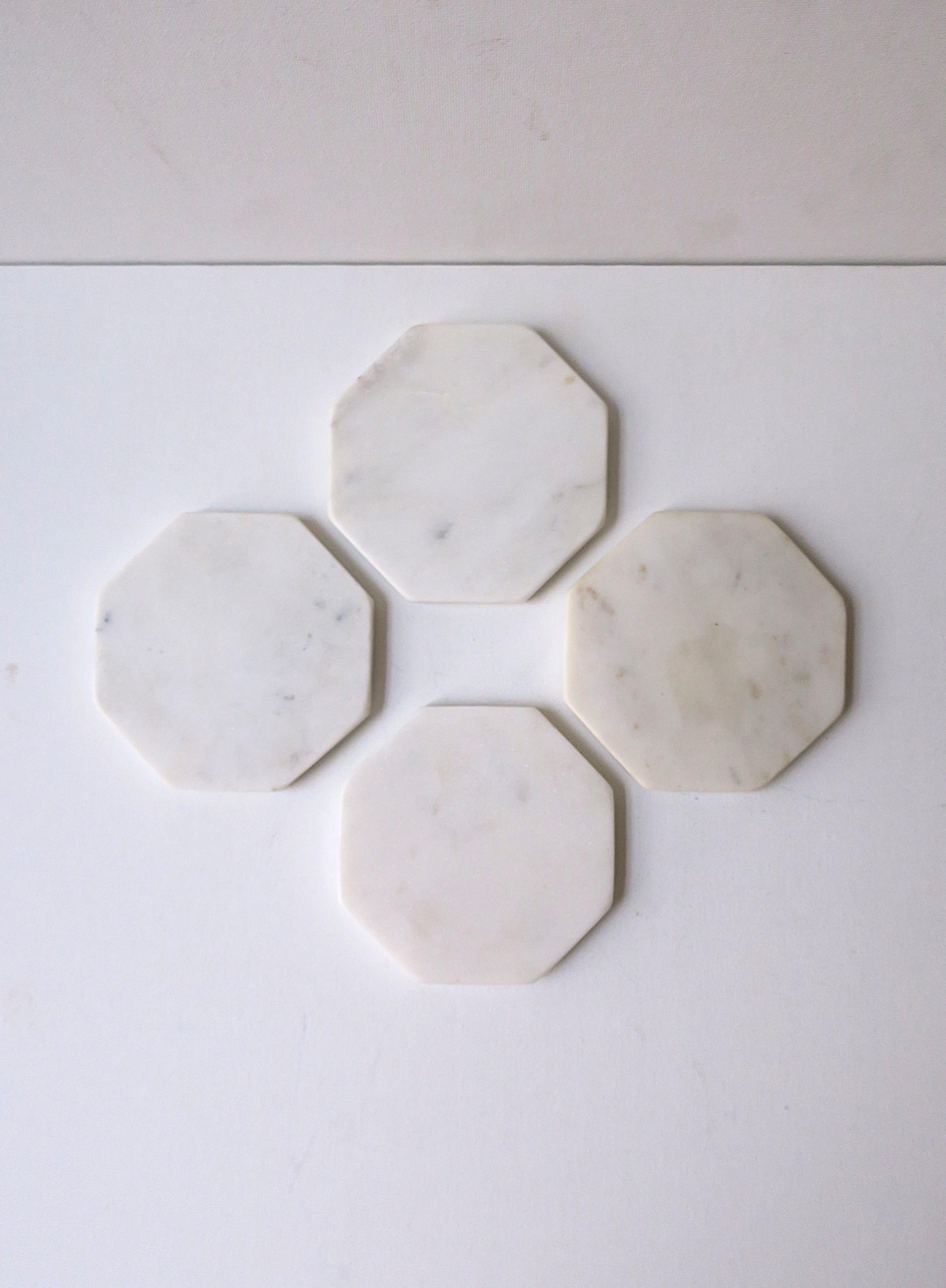 A set of four (4) white marble cocktail drinks coasters with traces of dark veining, in the modern style. A great set with an octagonal shape, light veining, and small round protectives on bottom. Perfect for drinks, cocktails, champagne, etc. A