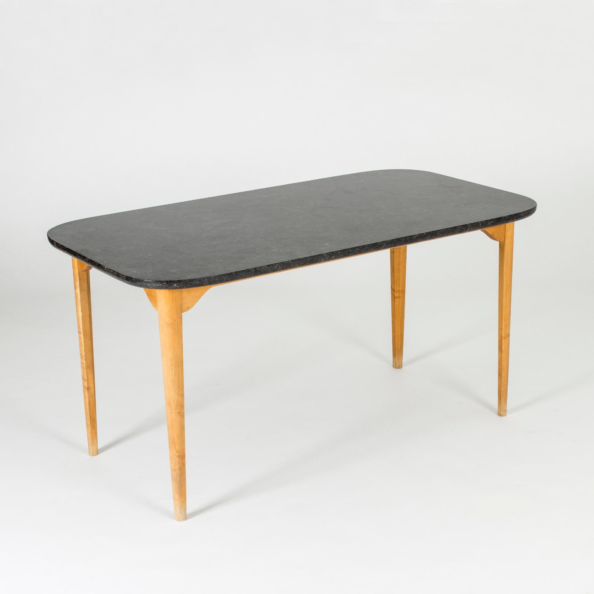 Coffee or playing table by Axel Larsson. Heavy black marble table top and birch base with an open and light look. Nice modernist design with a subtle traditional touch.
