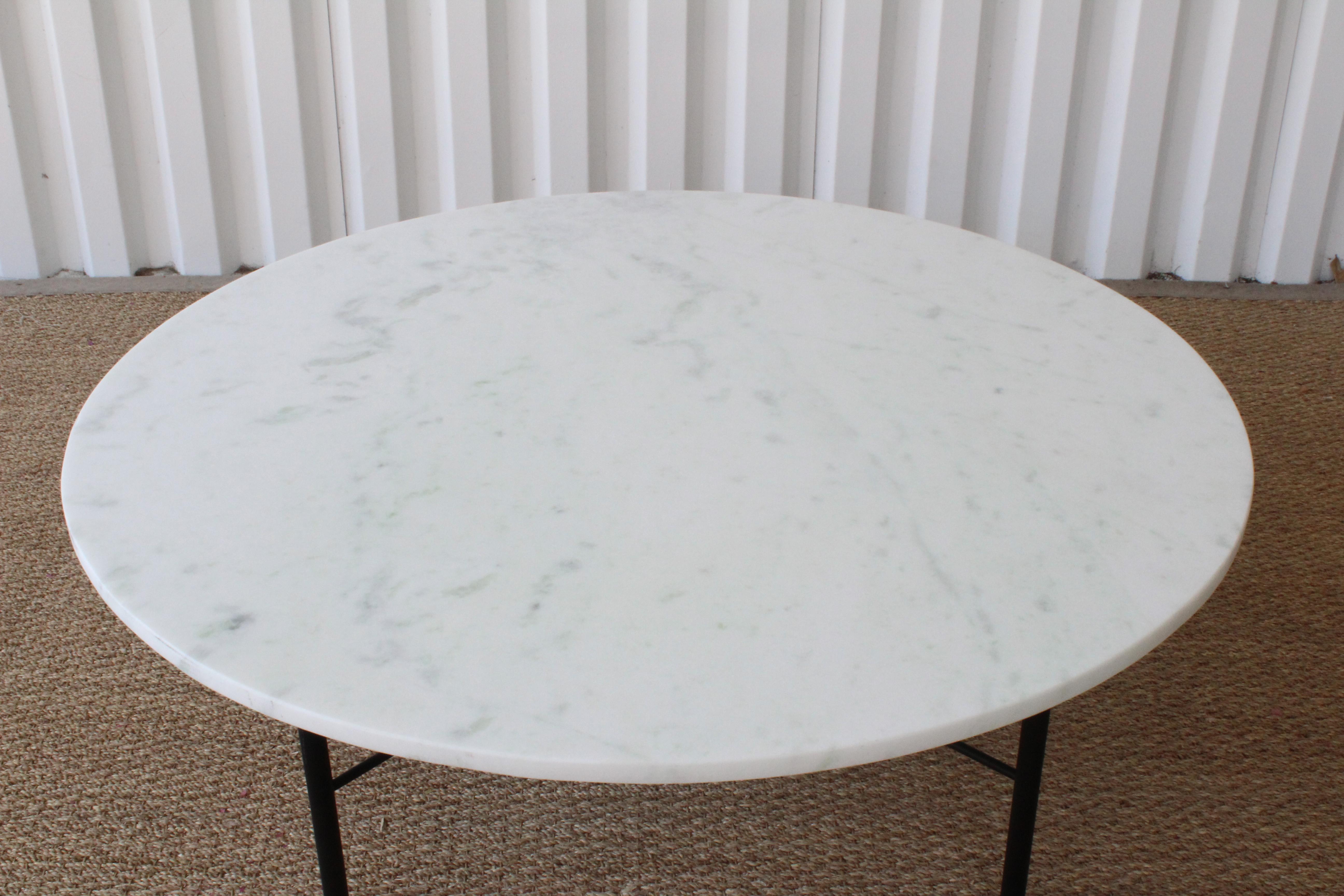 Custom marble coffee table on a steel base. The marble has been honed, meaning it has not been polished, giving it a matte appearance. Black powder-coated finish on the base.