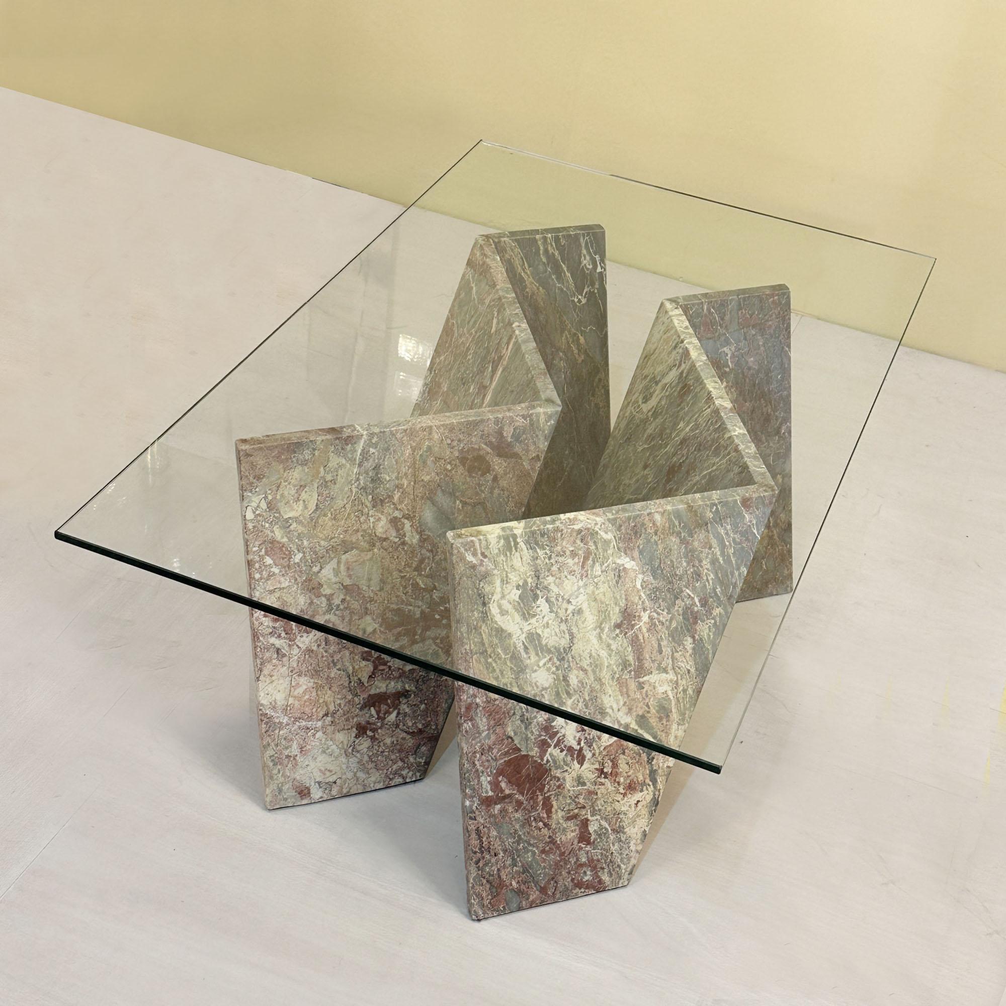 Mesa de centro escultórica de mármol con tapa rectangular de cristal, Italia Años 70. La base está formada por dos formas paralelas de mármol inclinadas en zig-zag, con una tapa de cristal rectangular de 12 mm.
Para el envío, la base se presenta en