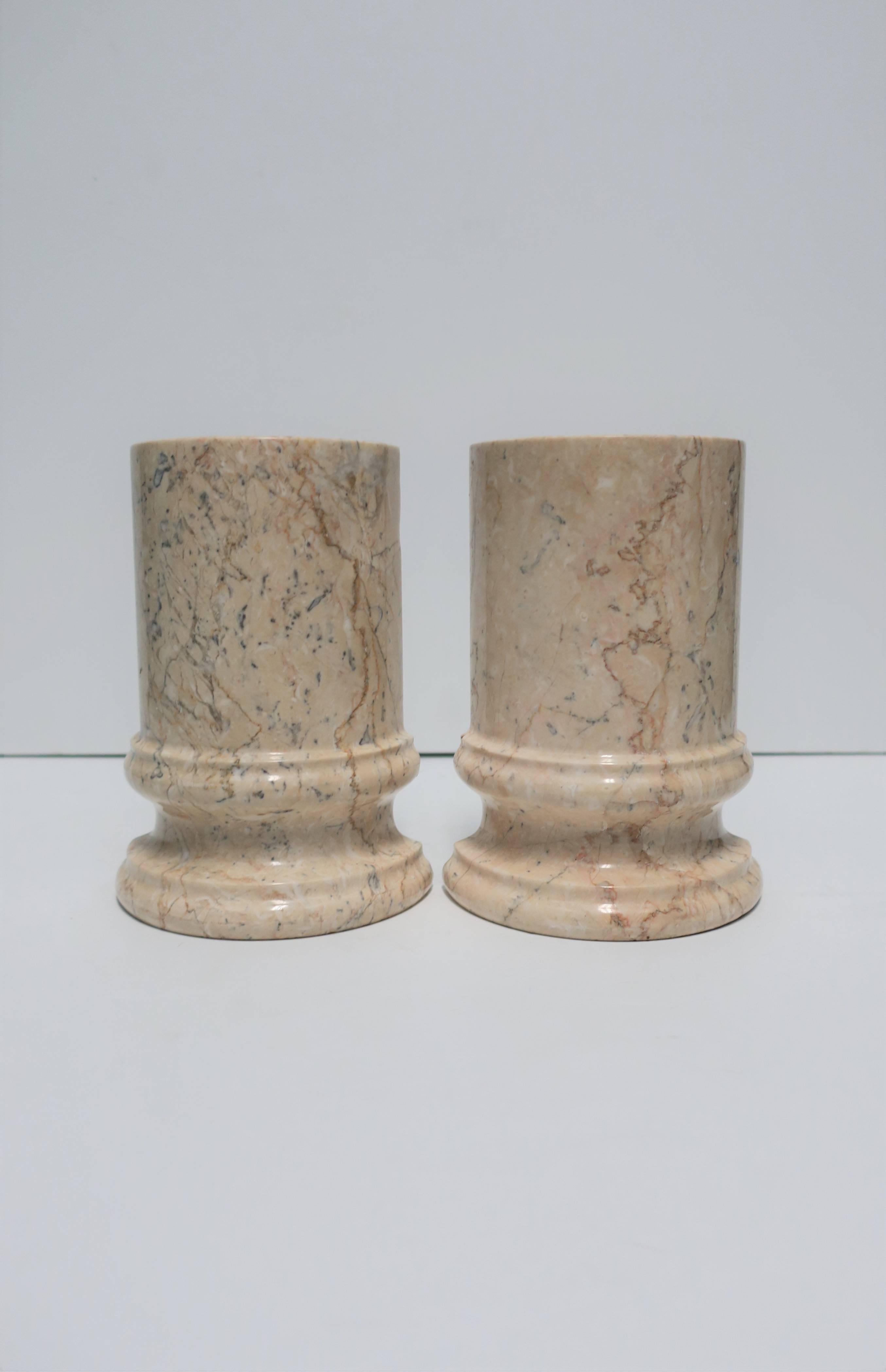 Pair of substantial vintage marble 'column' bookends in a predominantly tan or sand hue. 

Each bookend measures: 5 in. W x 7 in. H

