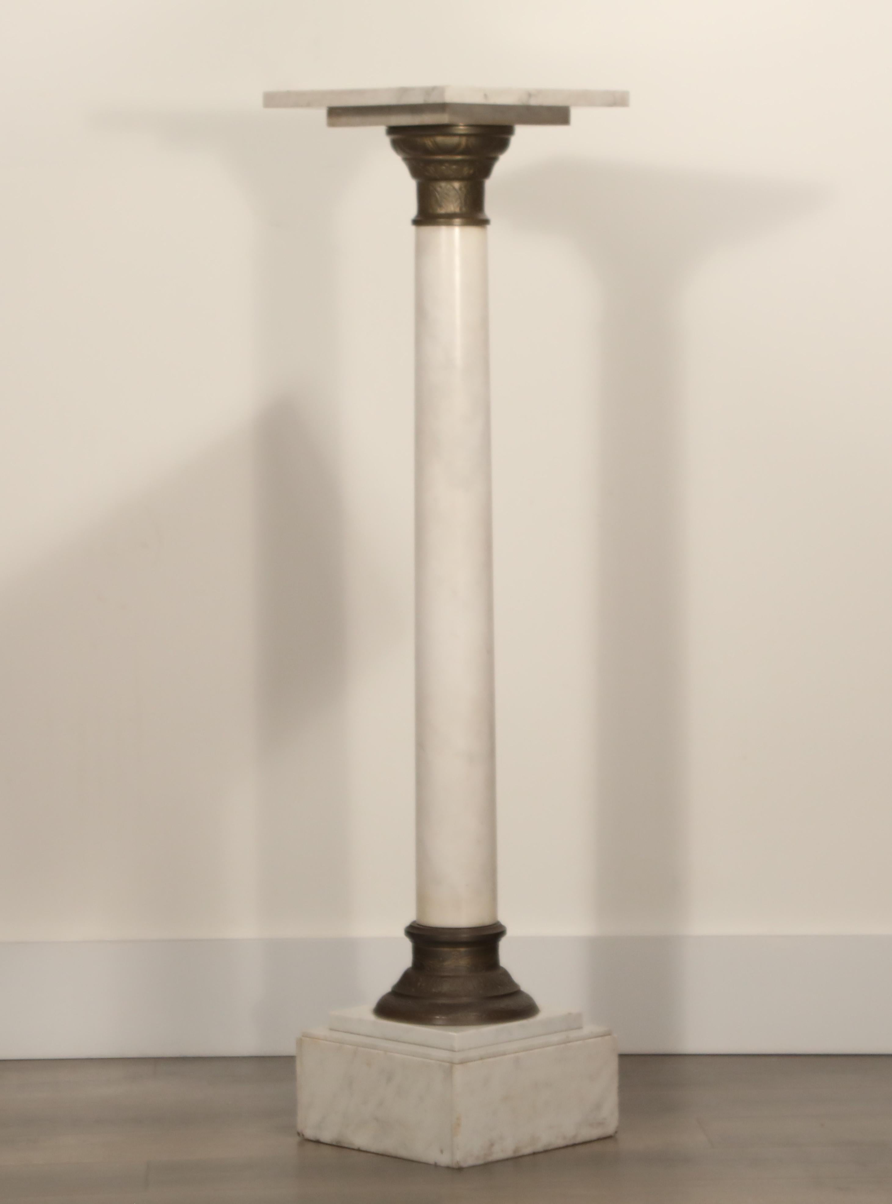 A classic 1930s Art Deco marble and patinated metal column pedestal. The square marble top perches over a columnar support raised on a stepped terraced marble base and set with patinated metal mounts. 

Consider using this as a floor stand for a