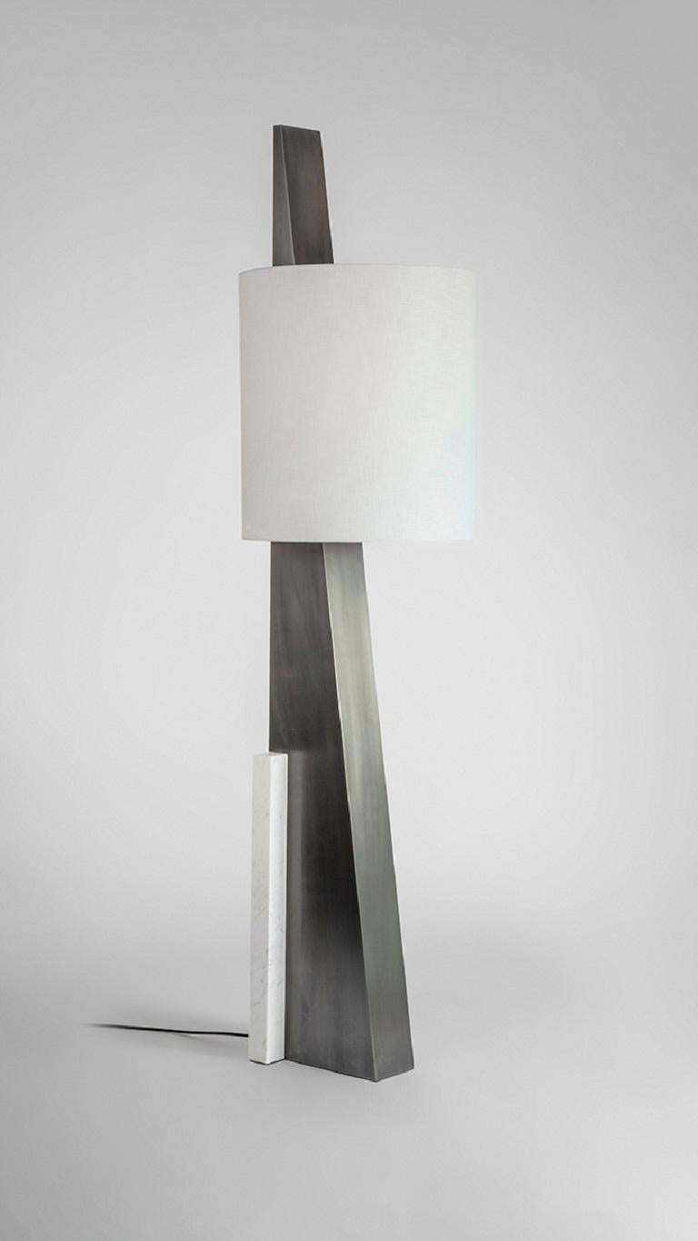 Marble Cut Triangle II Table Lamp by Square in Circle
Dimensions: D 45 x H 180 cm
Materials: Brushed grey metal, white cotton shade with white lining, white marble.

Inspired by the El Lissitzky poster beat the whites with red wedge, this oversized