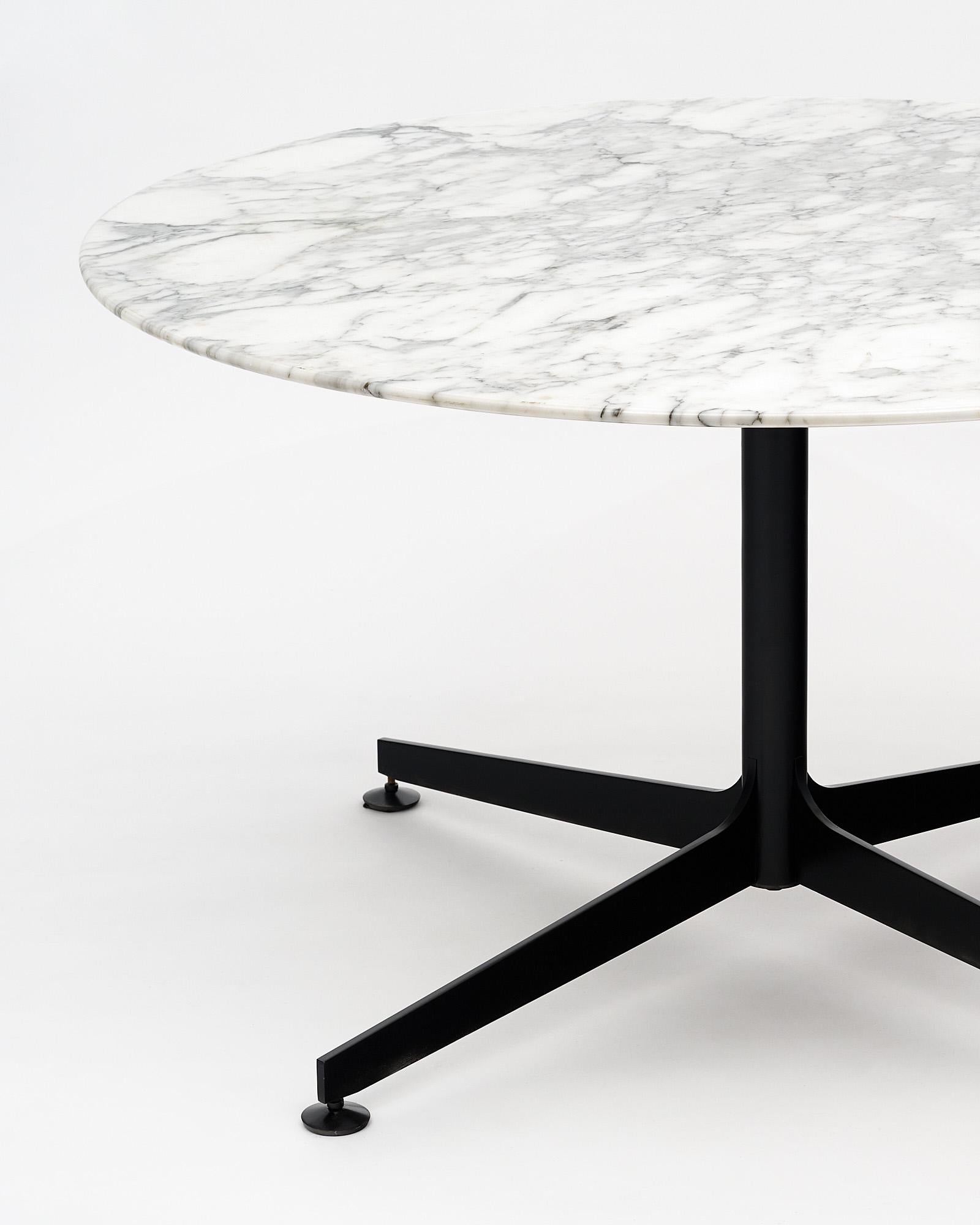 Round marble dining room table by Knoll with a black steel base supporting an intact, thick, veined Carrara slab. Adjustable feet.