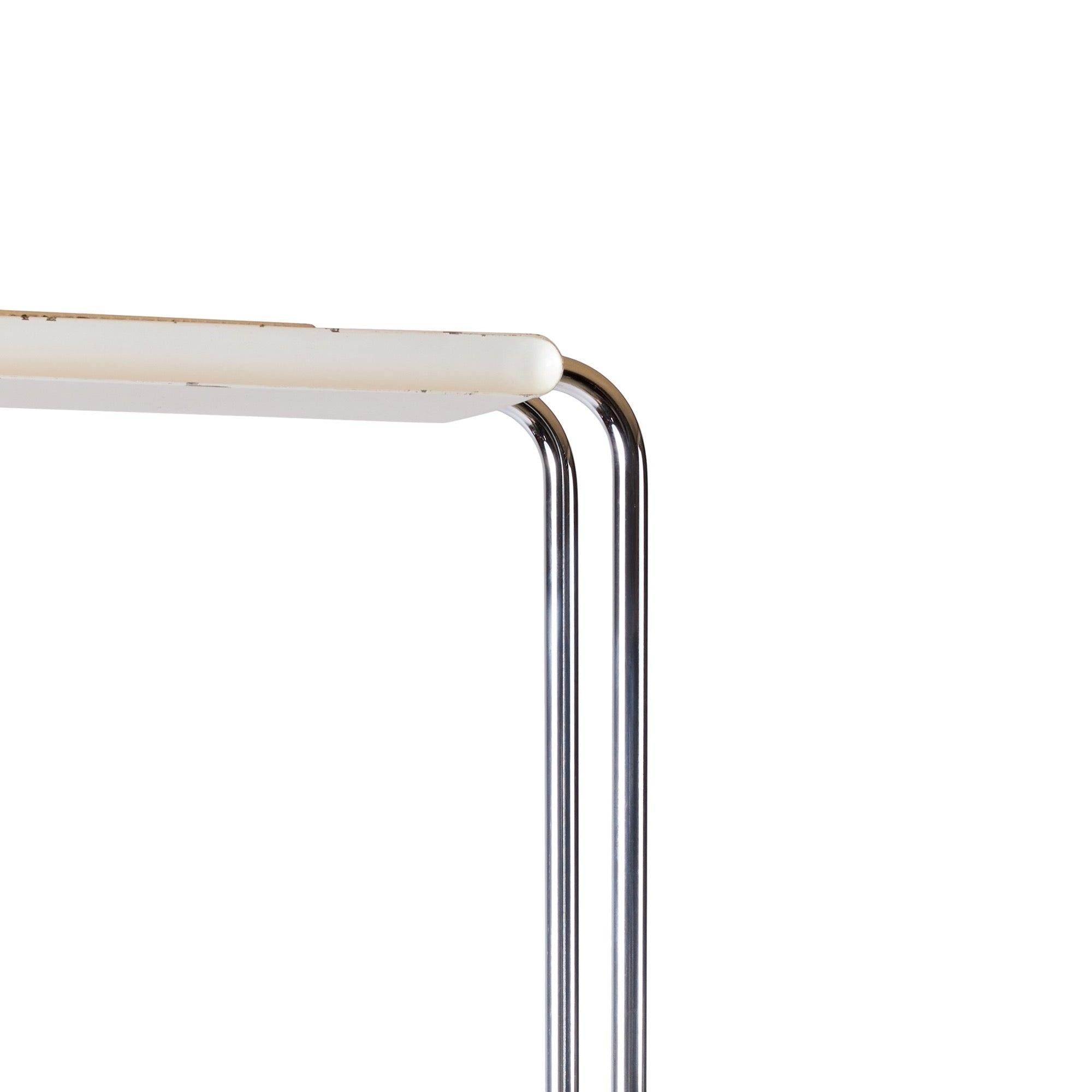 A sculptural Italian halogen floor lamp with a carved marble base; which, houses a recessed handle and supports parallel steel uprights and a Modern white enameled hood.