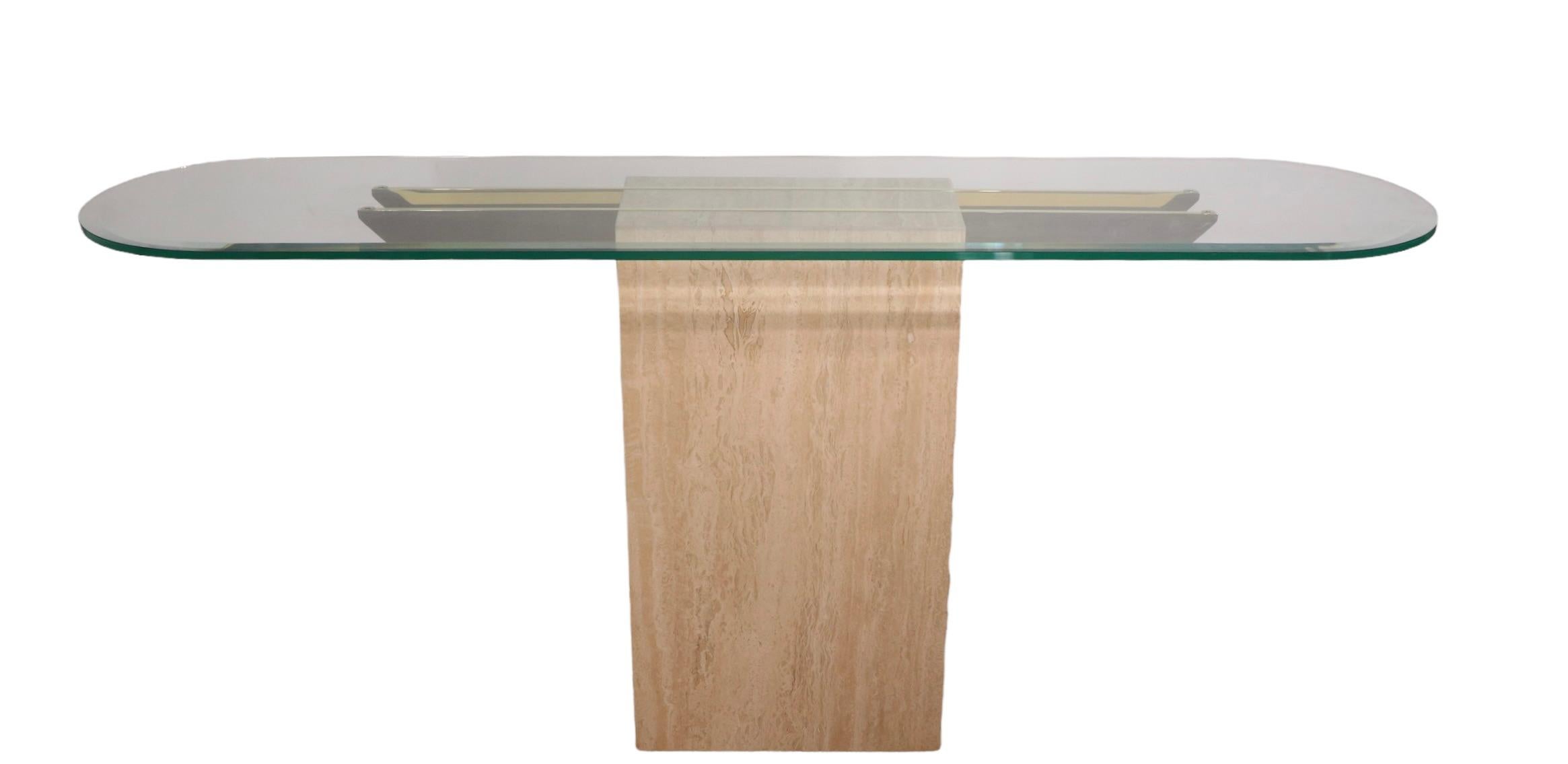 Chic Artedi console table, in very clean, original ready to use condition. The base is a rectangular marble, with two horizontal brass supports and an unusual plate glass oval top. The top features a nice wide bevel, adding to the beauty and
