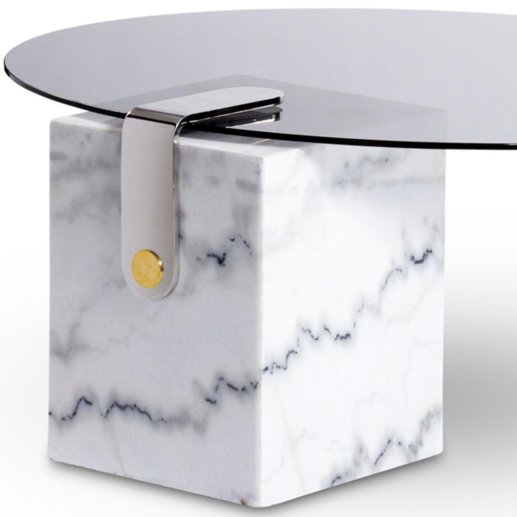 La table basse ronde patch en marbre fait partie de la collection Patch de Egg Designs. Patch fait référence au mécanisme de fixation en laiton conçu par Egg Designs et utilisé sur de nombreux meubles. La table basse a une base en marbre avec un