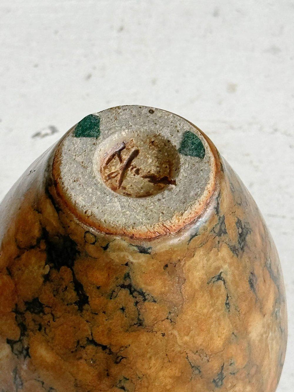 Ce vase en forme d'urne, d'inspiration marbrière et à la poignée marron vintage, présente une glaçure marbrée de couleur terre, exsudant élégance et charme rustique. Avec son design classique et ses couleurs riches, il ajoute une touche de beauté