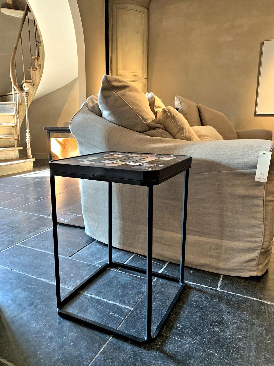 A side table made by our workshop from a 19th century tradesmen sample table and a custom metal base. The top having intarsia marble samples set in a sticking white veined black marble frame.