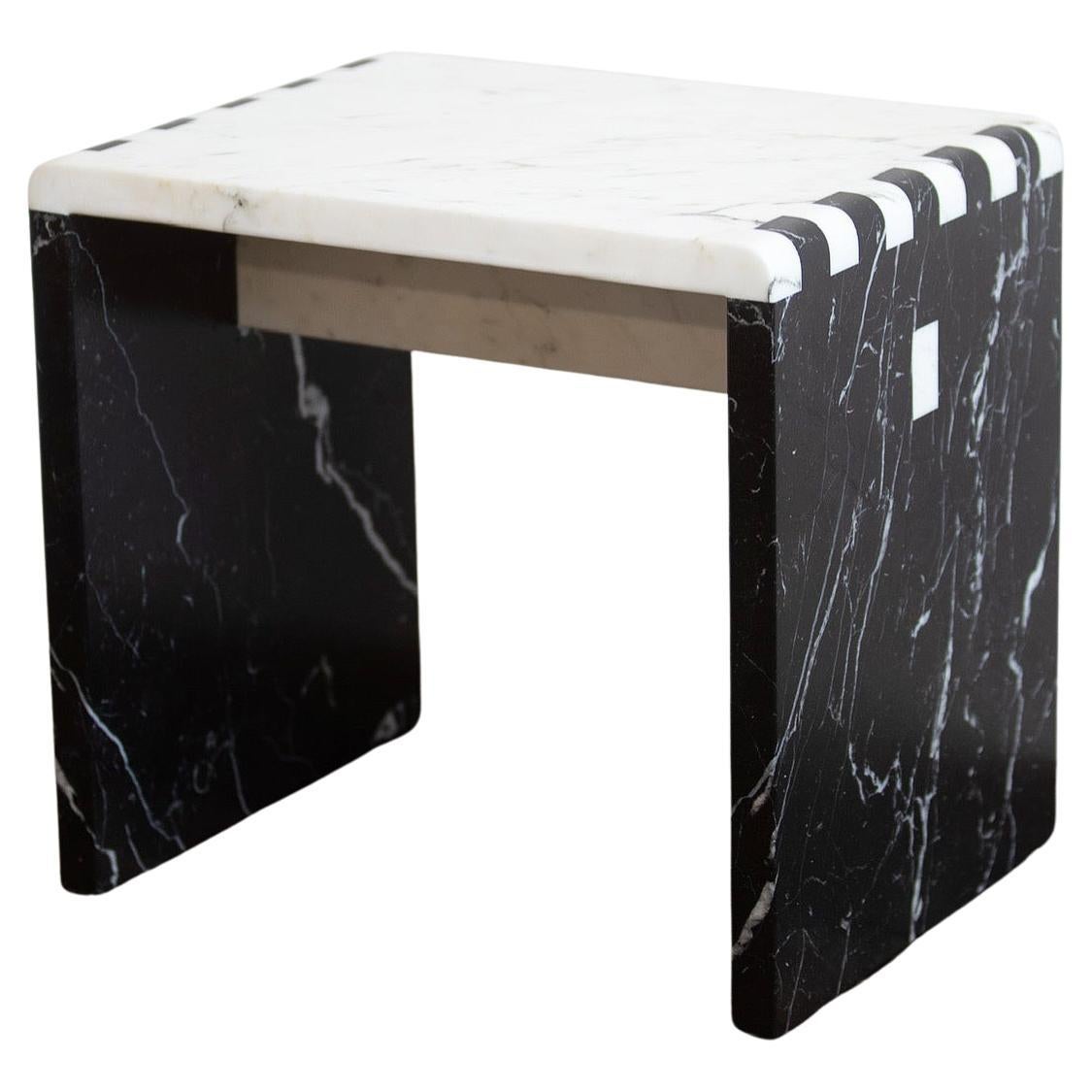 Inspired by traditional Japanese wood joinery, this minimalist stool/side table is a material study of stone. Shown in Calacatta Gold & Nero Marquina Marble. Sure to make a statement for any environment.