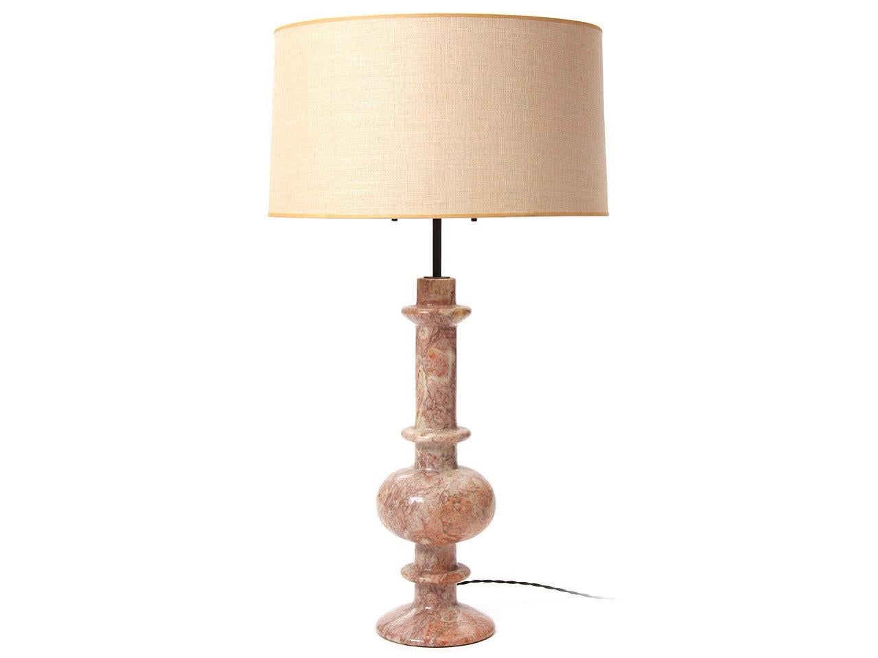 A table lamp with a lathe-turned pink marble base.