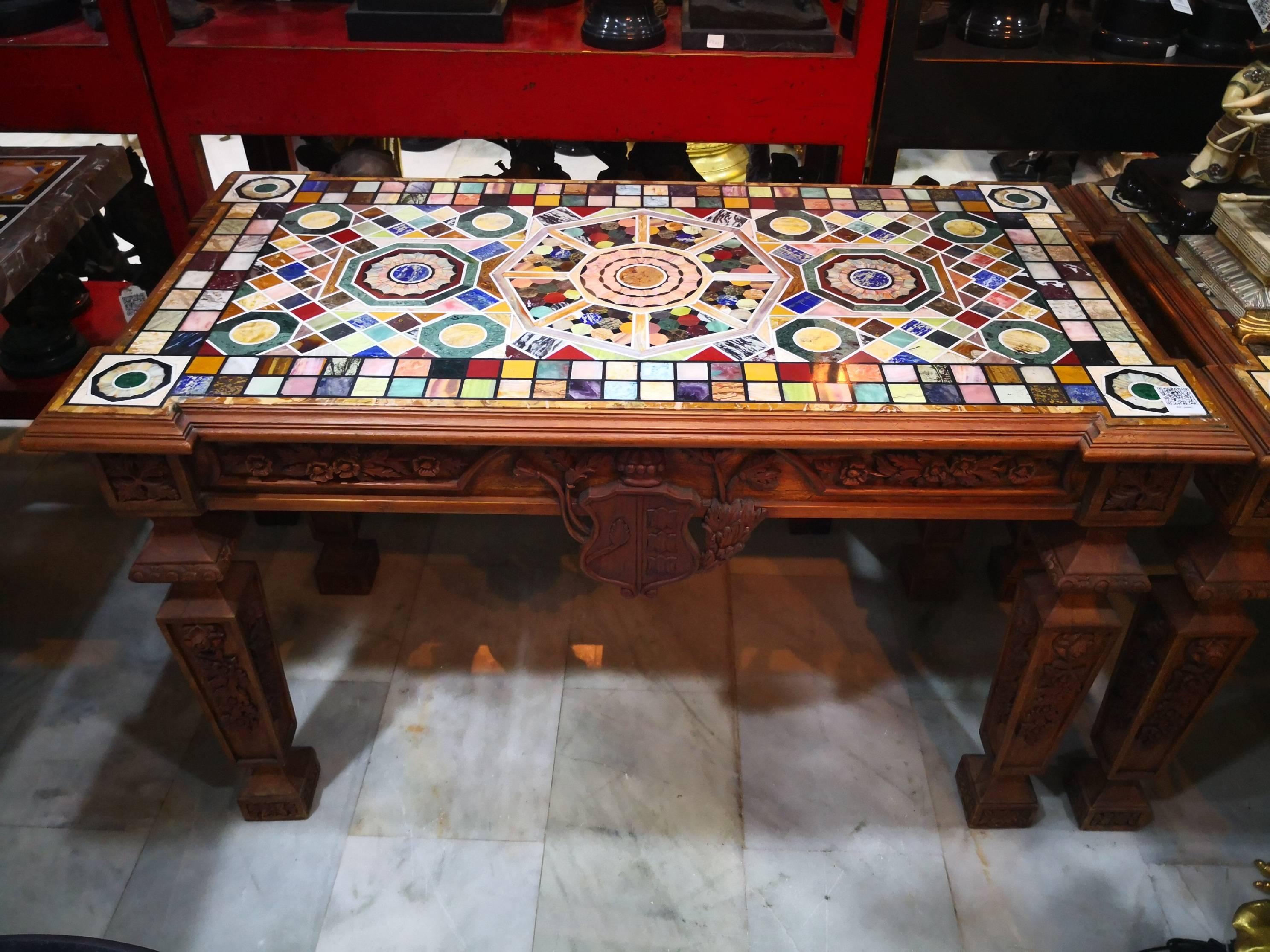 Pair of Italian tables with hand-carved wooden foot, with marble top in mosaic with a geometric decorations of semiprecious stones and marbles of different colors.

 