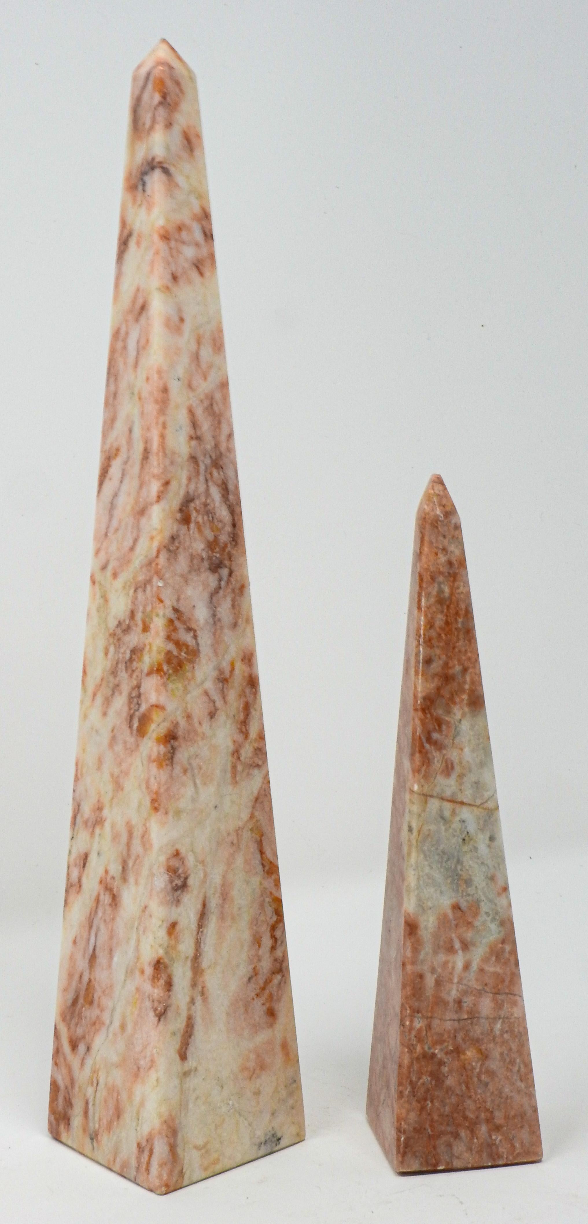 Offering this pair of vintage marble obelisk. The taller one has majority white with pink and salmon colored veining. The smaller of the two is more of the pink and salmon color with splashes of white and grey. Obelisk are great home accents to add