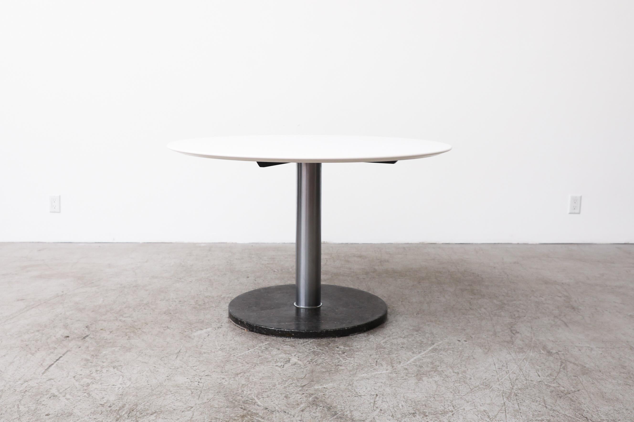 Round pedestal dining table with black marble base, chrome pedestal and white laminate table top. In original condition with visible wear, including visible wear and markings to the marble. Table top may not be original to the base. Wear is