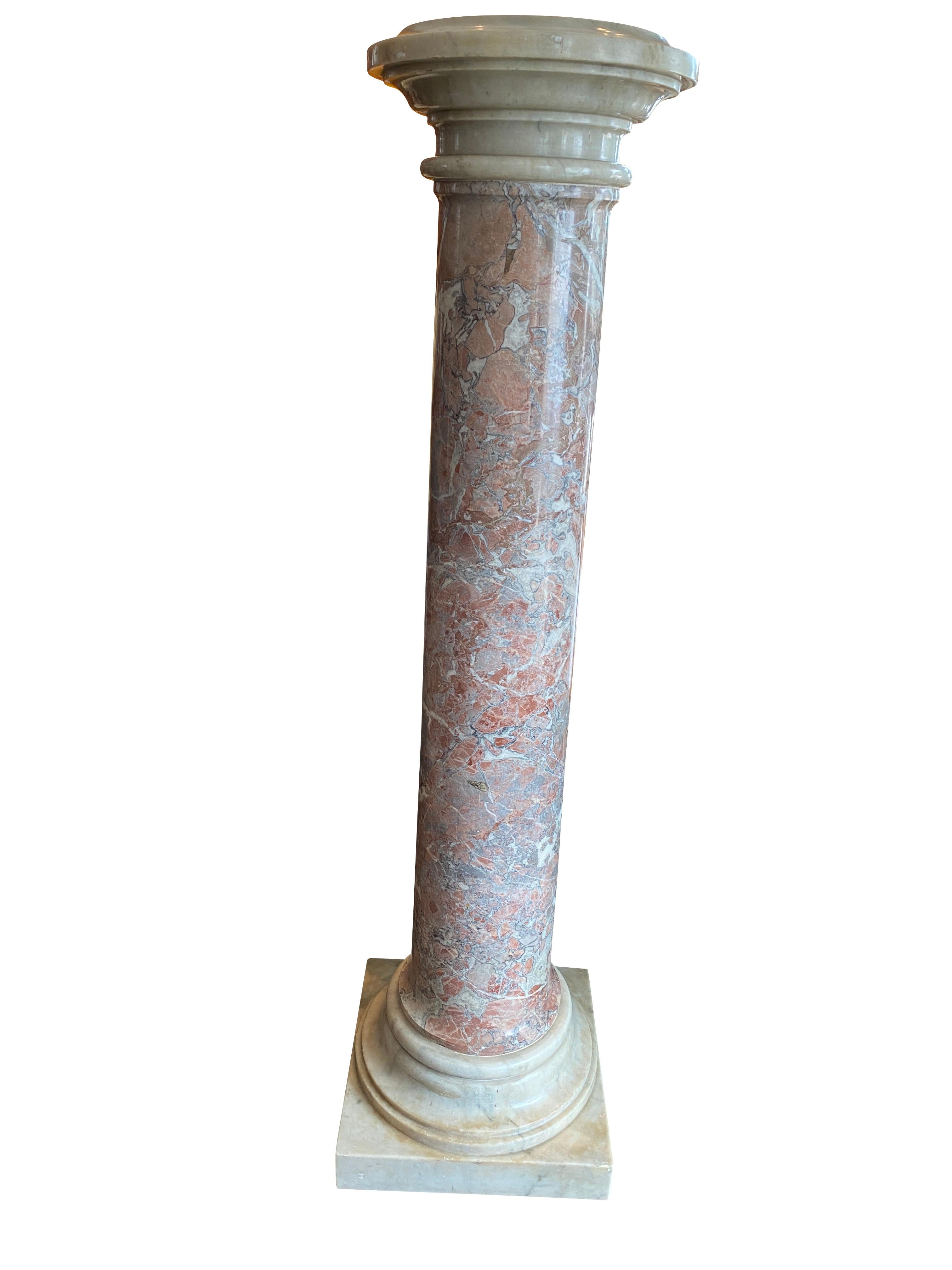 Cylindrical liver and white with white marble base and top.